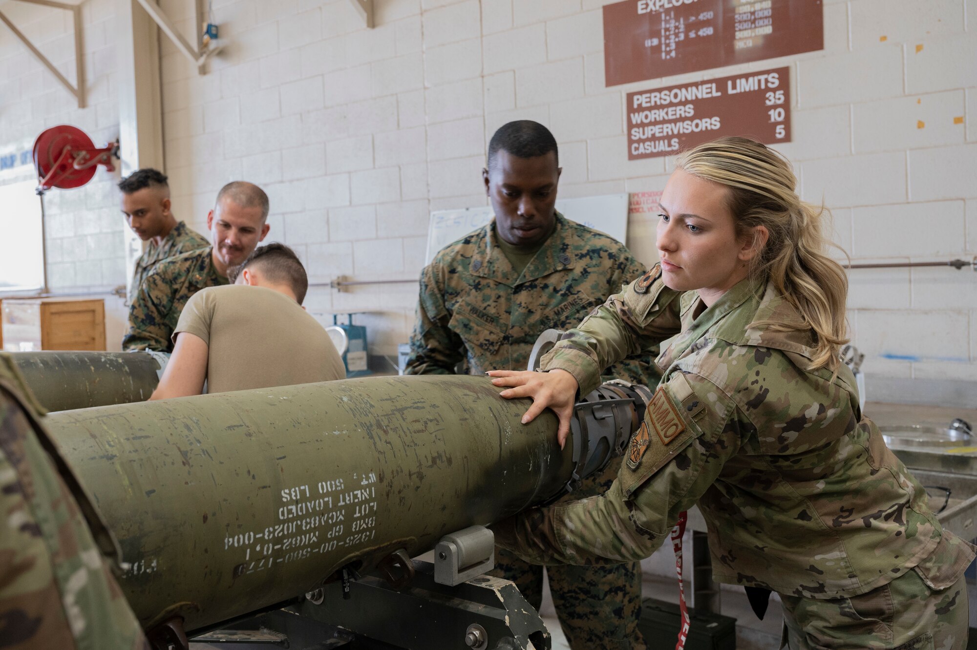 Airmen from the 7th Munitions Squadron and Detachment 1, 4th Combat Logistics Battalion 453 Marines build GBUs during a bomb building event at Dyess Air Force Base, Texas, Dec. 12, 2023. The event allowed 7th MUNS Airmen to showcase their day-to-day job and how it ties into the overall Air Force global deterrence mission to Dyess joint service members. (U.S. Air Force photo by Airman 1st Class Alondra Cristobal Hernandez)