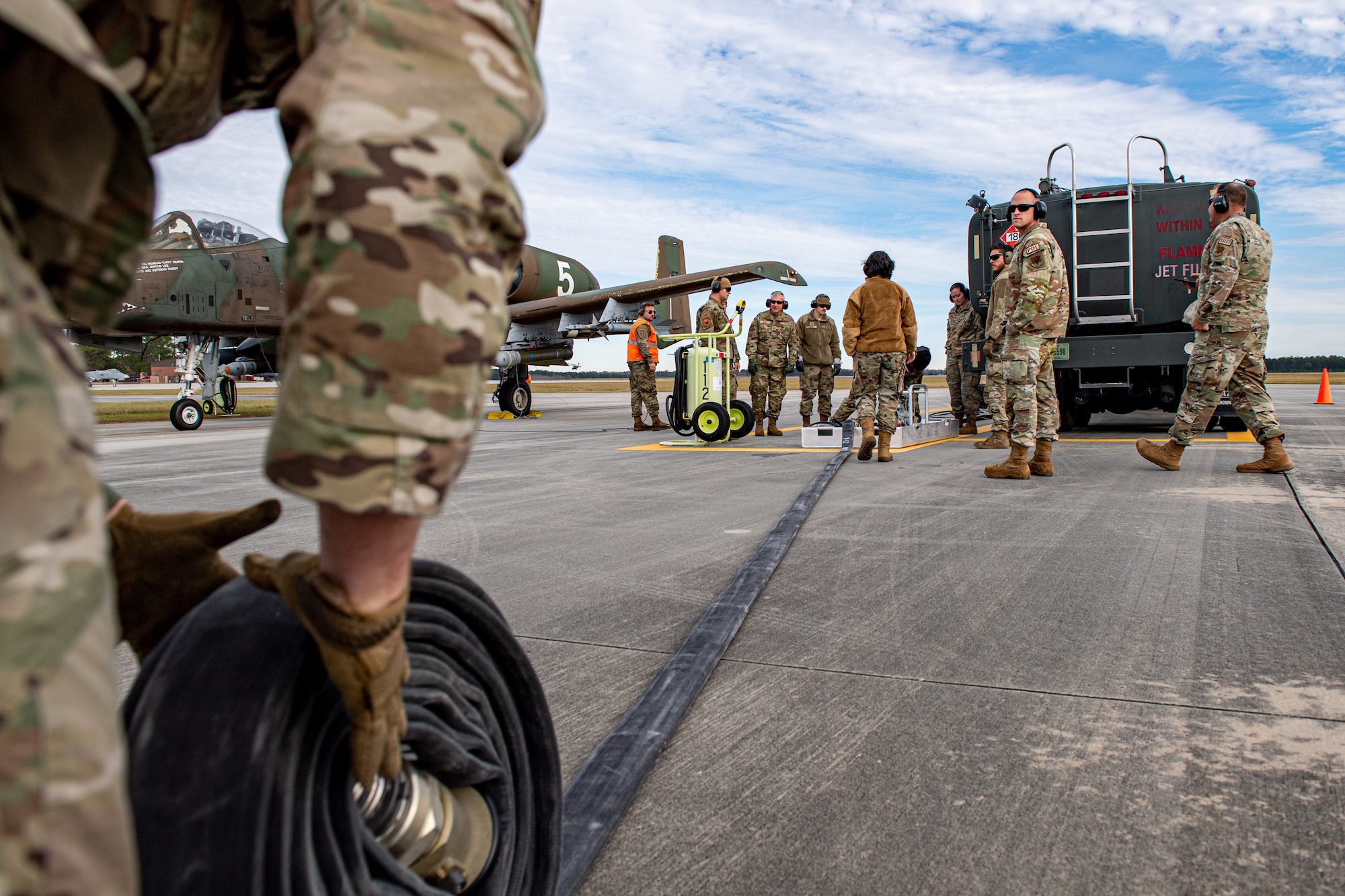 A U.S. Air Force Airman assigned to the 23rd Logistics Readiness Squadron rolls a fuel hose during a special fueling operations familiarization training at Moody Air Force Base, Georgia, Dec. 13, 2023. Over a three-day period, Airmen trained Vermont Air National Guardsmen on special fuel operations that support Agile Combat Employment (ACE) concepts. (U.S. Air Force photo by Senior Airman Courtney Sebastianelli)