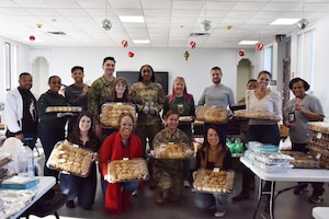 The Andrews Spouses Club and volunteers across the National Capital Region pose for a photo Dec. 15, 2023, at Joint Base Andrews, Md. The Andrews Spouses Club hosted a cookie gathering and packing event to be delivered to dorm residents by the base first sergeants to help spread cheer during the holidays. (U.S. Air Force photo by Staff Sgt. Daniel Brosam)