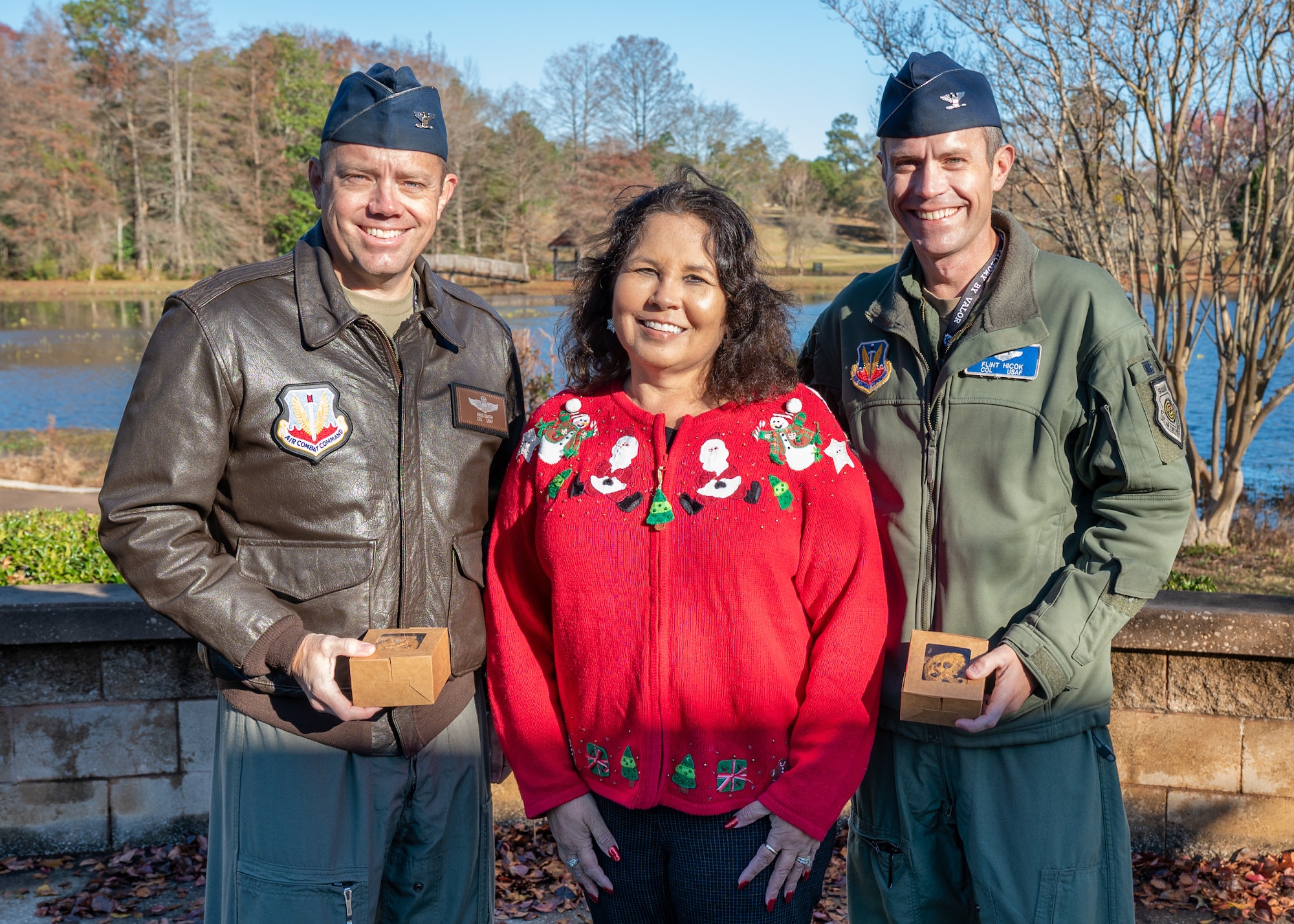 Two men and a woman pose for a photo standing.
