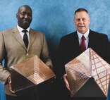 Two men hold their invention.