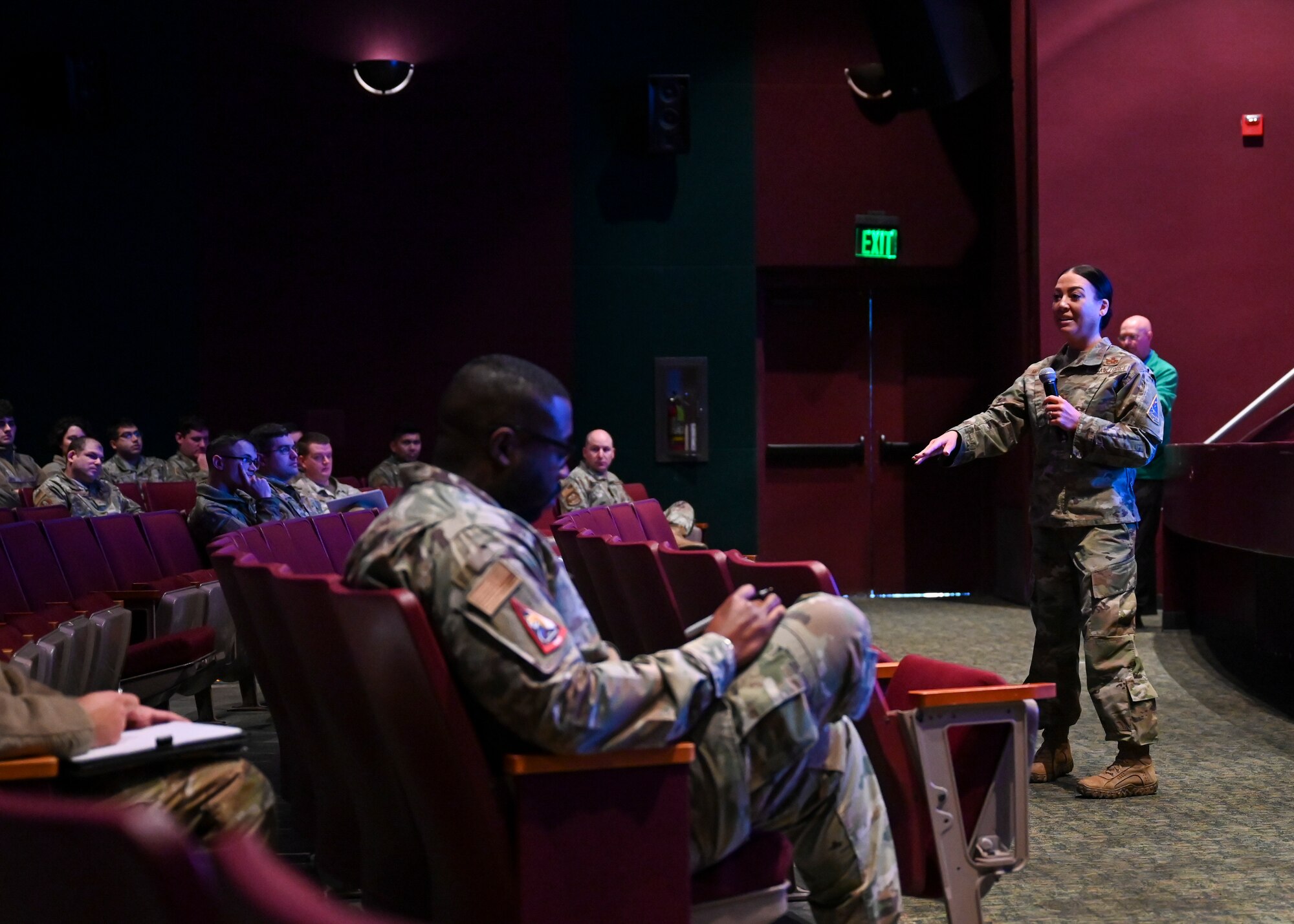 Mr. Mead stands on a stage pointing a people in the crowd to answer individuals questions.
