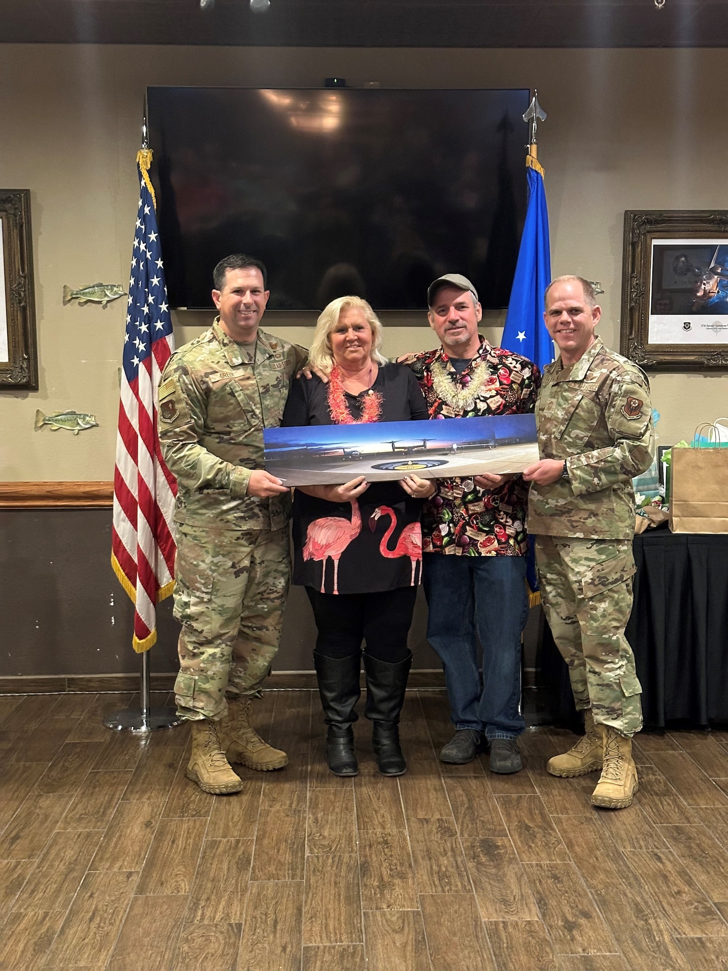 Col. Brent Greer, 27th Special Operations Wing Deputy Commander, and Chief Master Sgt. Colin Fleck, 27th SOW Command Chief, present Jean Masters, Cannon Air Force Base Sexual Assault Response Coordinator, and Rick Masters, 27th SOW outgoing Director of Staff, with a gift from the Air Commandos of Cannon AFB, Dec. 5, 2023, at the Landing Zone, Cannon AFB, N.M. The Masters’ have guided Air Commandos at Cannon AFB since 2007. (Courtesy Photo)