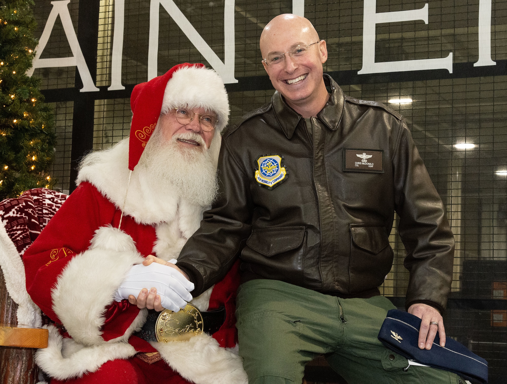 U.S. Air Force Col. Chris McDonald, right, 436th Airlift Wing commander, sits by Greg ‘Santa’ Miller, during Operation Feed the Troops at Dover Air Force Base, Delaware, Dec. 13, 2023. This year, more than 800 meals were served to active duty, Reserve and civilians, as well as their family members during two different meals for day and night shift workers. (U.S. Air Force photo by Roland Balik)