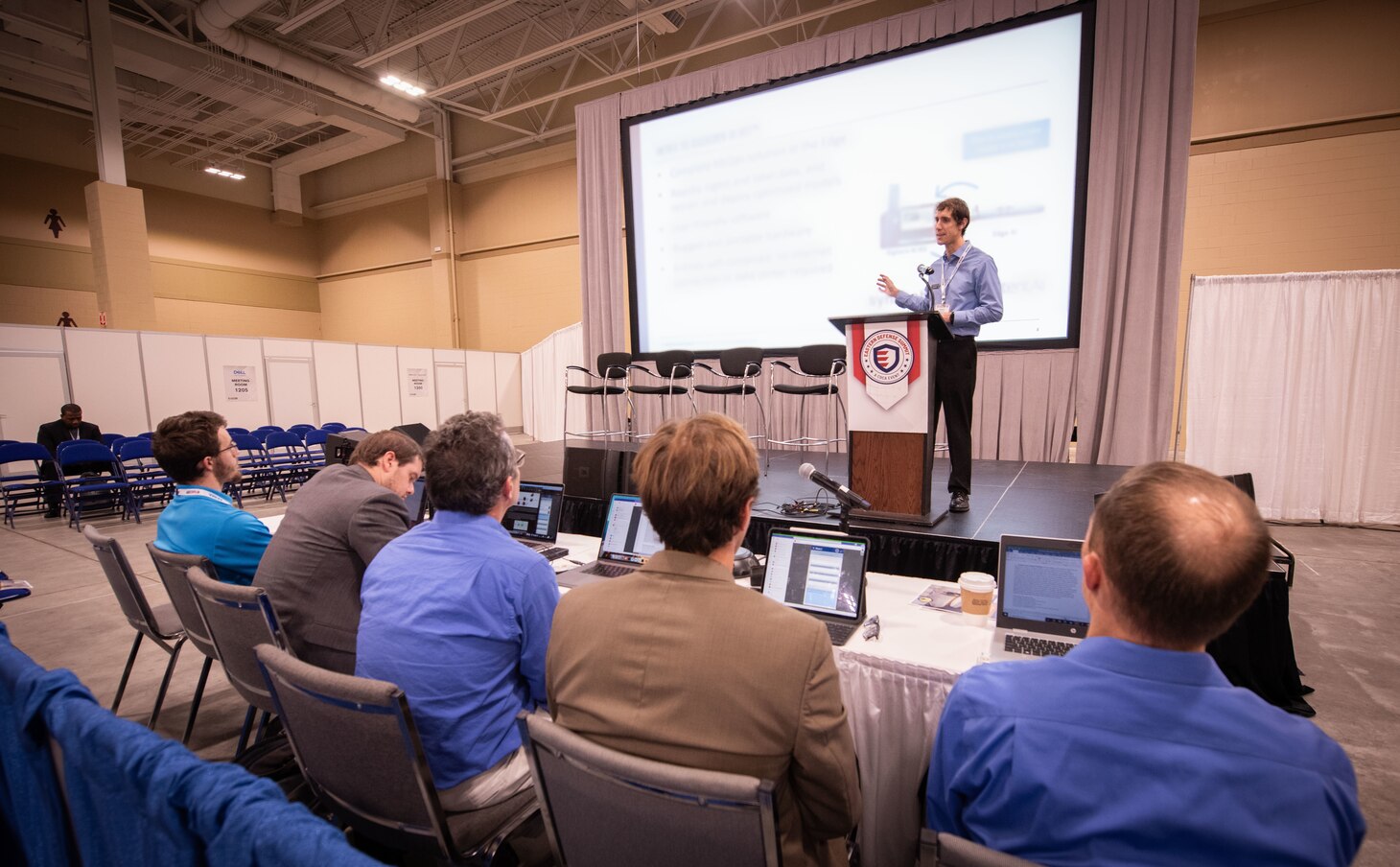 A panel of five government scientists and engineers from Naval Information Warfare Center (NIWC) Atlantic listen to a company’s technical proposal during the Multilateral Autonomy Prize Challenge. Organized by NIWC Atlantic’s Palmetto Tech Bridge in conjunction with the Charleston Defense Contractors Association (CDCA), the final phase of the competition took place during the Innovation Pitch Jam of the CDCA’s 2023 Eastern Defense Summit. Organizers said nearly three dozen submissions were narrowed down to eight in-person pitches.