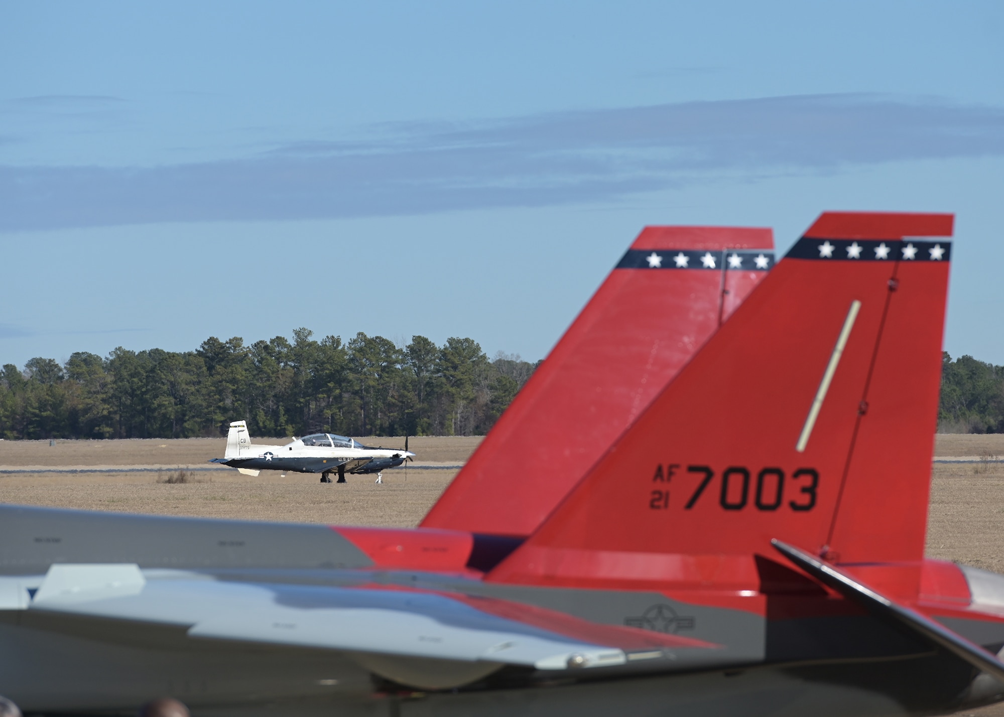 A T-6 Texan II is seen passing a T-7A Red Hawk.