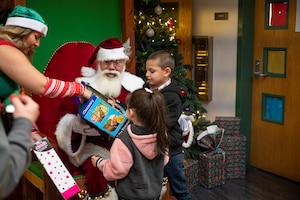 Santa gives toys to kids.