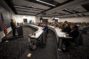 man presents in front of room of people