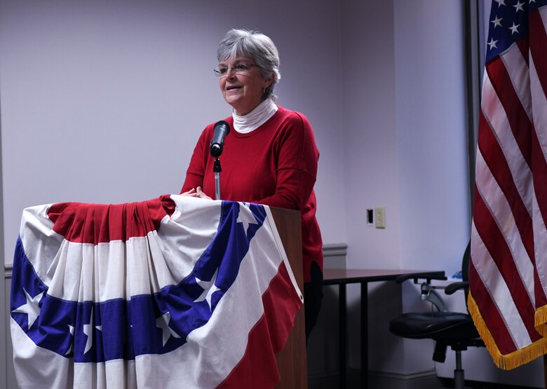 woman stands at podium