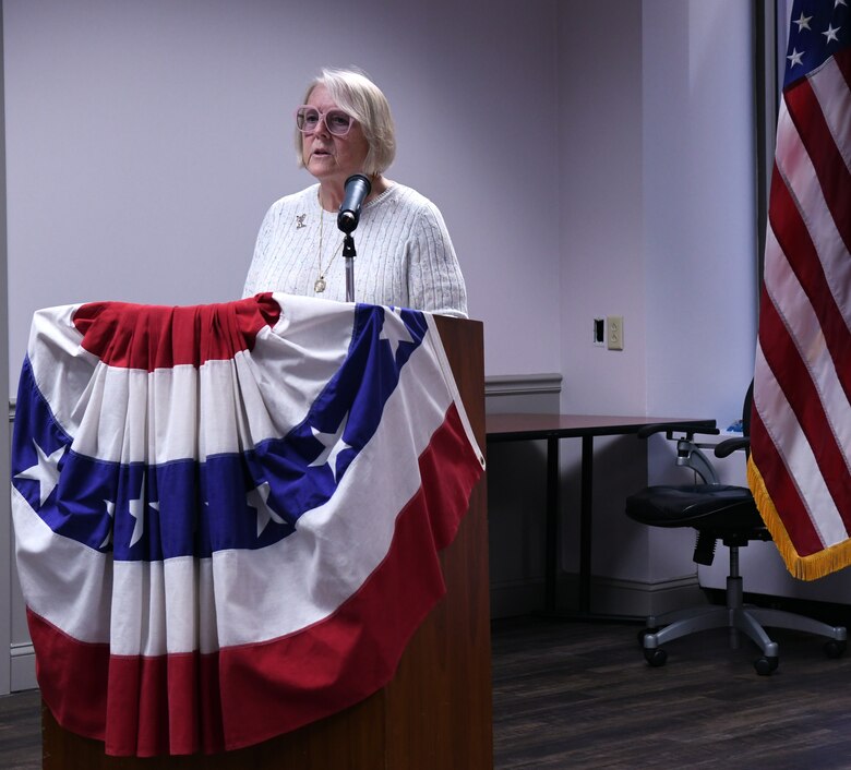 woman stands at podium