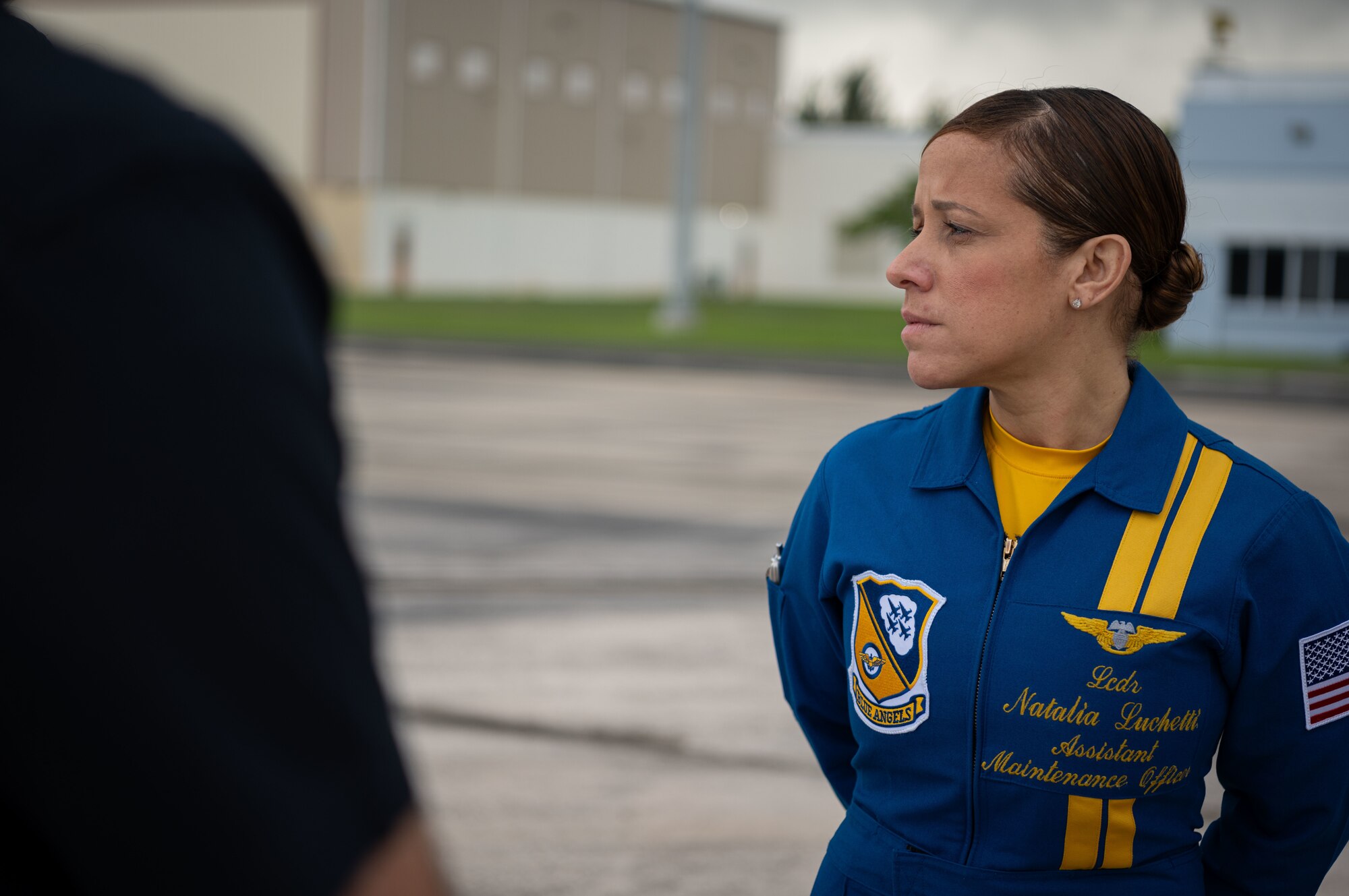 U.S. Navy Lt. Cmdr. Natalia Luchetti, the assistant maintenance officer with the U.S. Navy Flight Demonstration Squadron, the Blue Angels, listens to crew members assigned to the U.S. Navy Flight Demonstration Squadron, the Blue Angels, at the 156th Wing airfield, Muñiz Air National Guard Base, Carolina, Puerto Rico, Dec. 15, 2023. The U.S. Navy Blue Angels participated in a campaign with Toys for Tots, which impacted communities across the Island in an effort to distribute more than 20,000 toys to local children during the holiday season. (U.S. Air National Guard photo by 2nd Lt. Eliezer Soto)