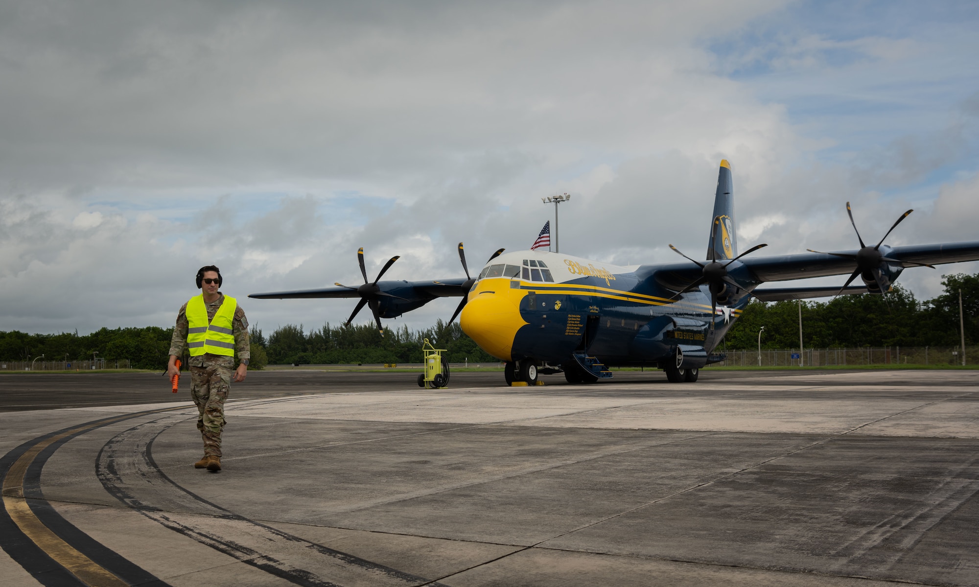 U.S. Air Force Master Sgt. Alexis Hernandez, an aerospace maintenance craftsman with the 156th Contingency Response Group, walks on the 156th Wing airfield after marshaling a C-130J Hercules “Fat Albert” assigned to the U.S. Navy Flight Demonstration Squadron, the Blue Angels, at the 156th Wing airfield, Muñiz Air National Guard Base, Carolina, Puerto Rico, Dec. 15, 2023. The U.S. Navy Blue Angels participated in a campaign with Toys for Tots, which impacted communities across the Island in an effort to distribute more than 25,000 toys to local children during the holiday season. (U.S. Air National Guard photo by 2nd Lt. Eliezer Soto)