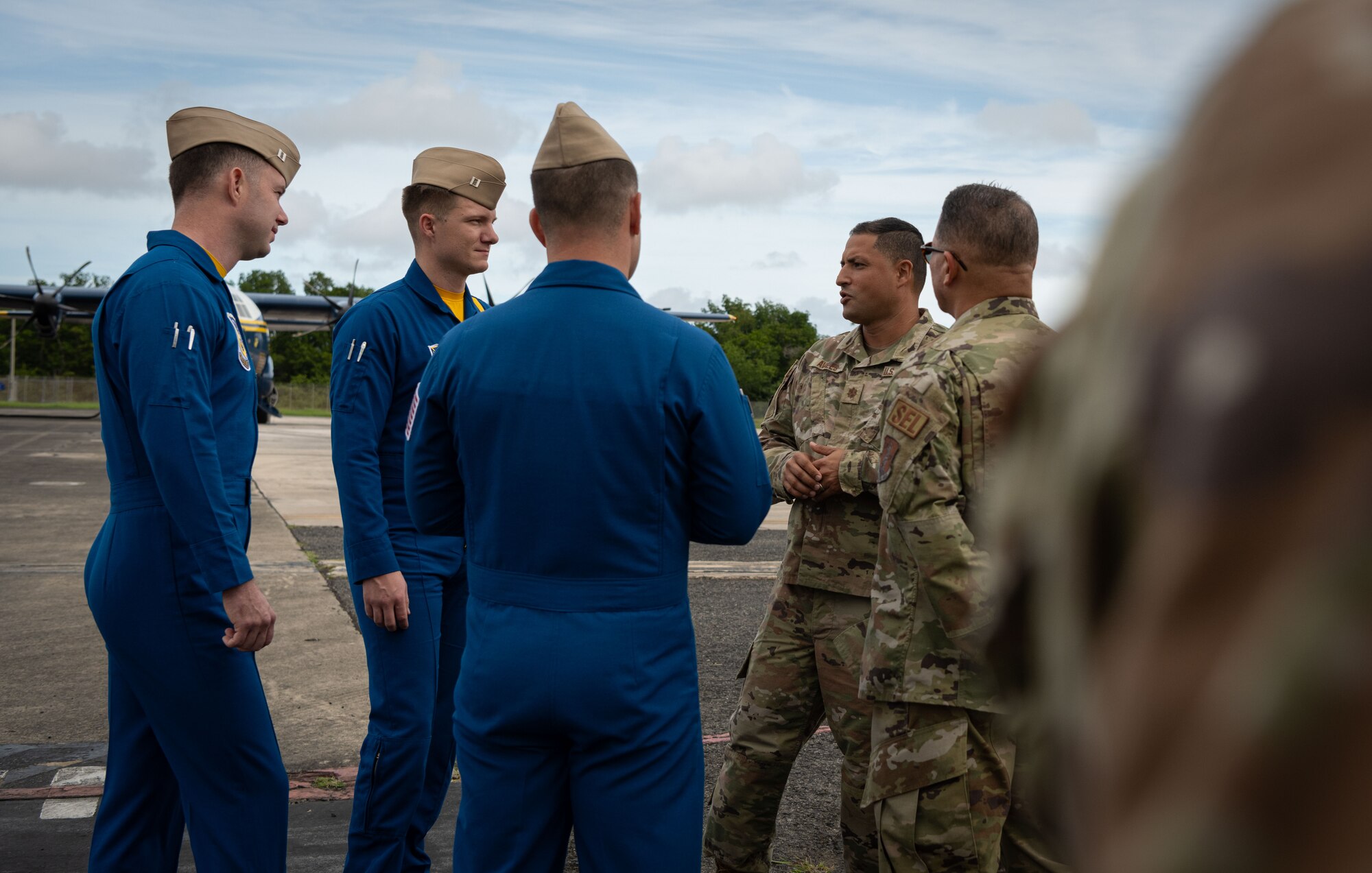 From right, U.S. Air Force Maj. Jesus Avilés, the 156th Wing plans officer, Puerto Rico Air National Guard, and Chief Master Sgt. Orlando Soto, the 156th Wing command chief, Puerto Rico Air National Guard, speak with U.S. Marine Corps officers with the U.S. Navy Flight Demonstration Squadron, the Blue Angels, at Muñiz Air National Guard Base, Carolina, Puerto Rico, Dec. 15, 2023. The Puerto Rico Air National Guard supported the U.S. Navy Blue Angels in a campaign with Toys for Tots, which impacted communities across the Island in an effort to distribute more than 25,000 toys to local children during the holiday season. (U.S. Air National Guard photo by 2nd Lt. Eliezer Soto)