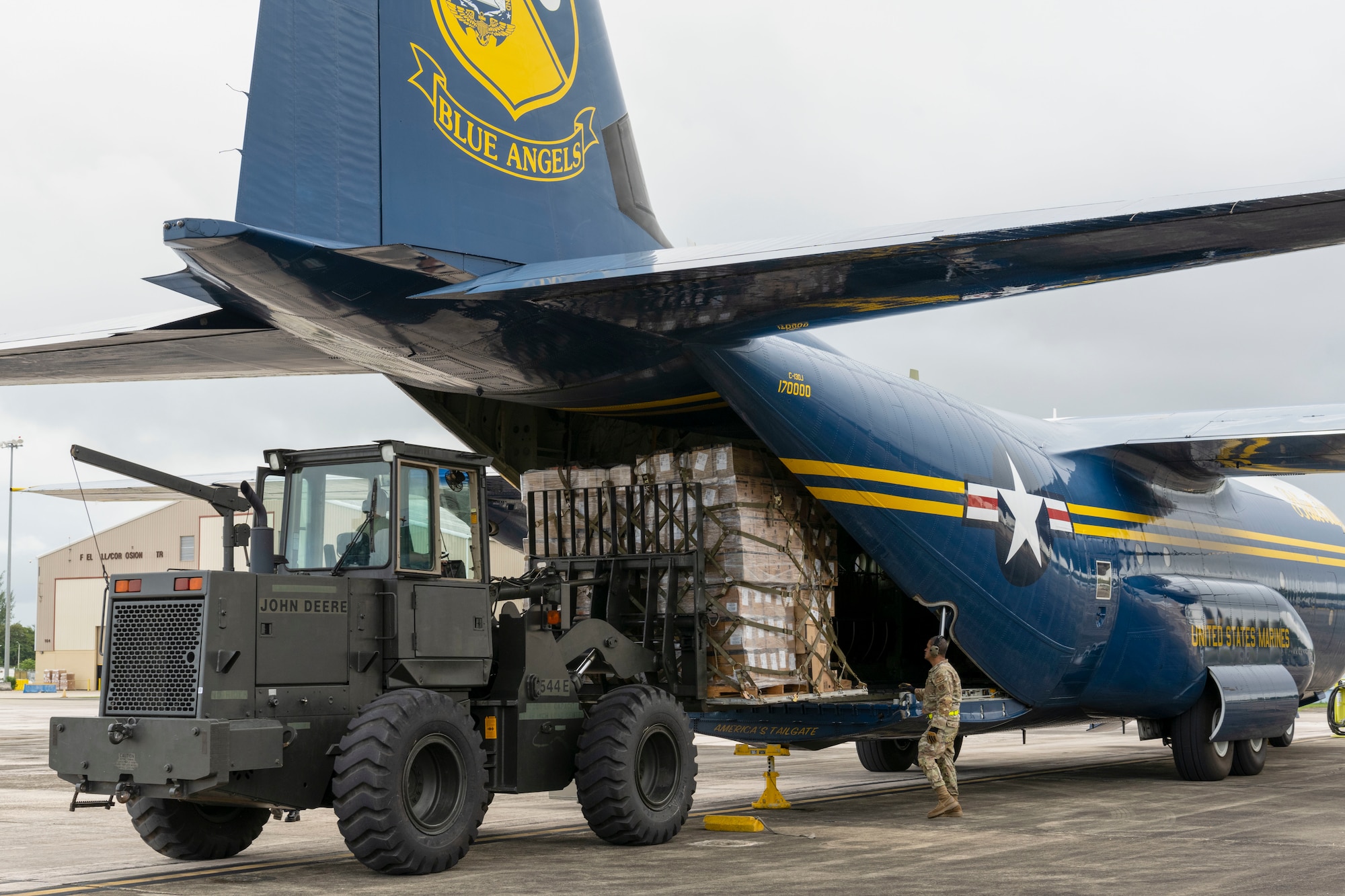 A U.S. Airman with the 156th Wing operates a forklift to unload wooden pallets from a C-130J Hercules “Fat Albert” assigned to the U.S. Navy Flight Demonstration Squadron, the Blue Angels, at the 156th Wing airfield, Muñiz Air National Guard Base, Carolina, Puerto Rico, Dec. 15, 2023. The U.S. Navy Blue Angels participated in a campaign with Toys for Tots, which impacted communities across the Island in an effort to distribute more than 25,000 toys to local children during the holiday season. (U.S. Air National Guard photo by Airman 1st Class Victoria Jewett)