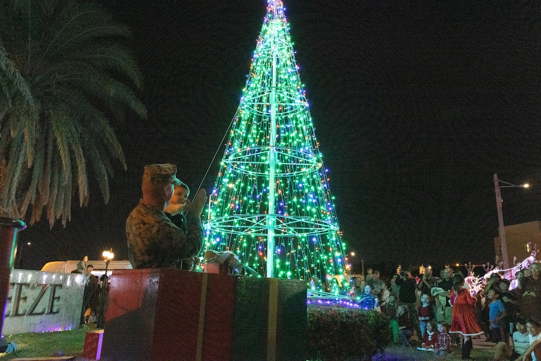 U.S. Marine Corps Sgt. Maj. Timothy Anderson, sergeant major of Headquarters and Support Battalion, Marine Corps Installations Pacific, gives a child a high five after lighting the Christmas tree on Camp Foster, Okinawa, Japan, Dec. 9, 2023. Marine Corps Community Services Okinawa hosted the Christmas tree lighting to give U.S. Marines and their families an opportunity to enjoy holidays away from home. (U.S. Marine Corps photo by Sgt. Kree Laing)