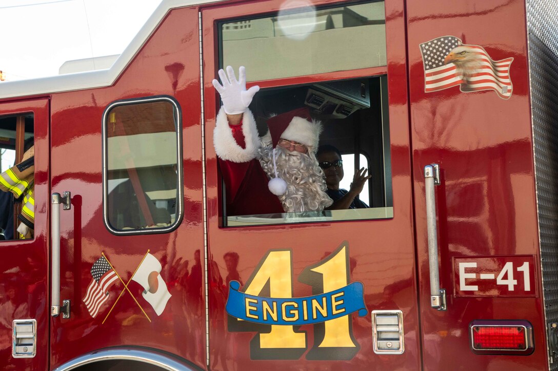 Santa Claus waves from a firefighter truck, from the Camp Schwab fire department, during the 42nd annual Camp Schwab & USO Christmas Children's Party at Okinawa, Japan, Dec. 9, 2023. The event is hosted every year for local children from the Henoko community to play games, eat food and receive presents as a token of appreciation for decades of friendship between the on and off base communities. (U.S. Marine Corps photo by Cpl. Martha Linares)