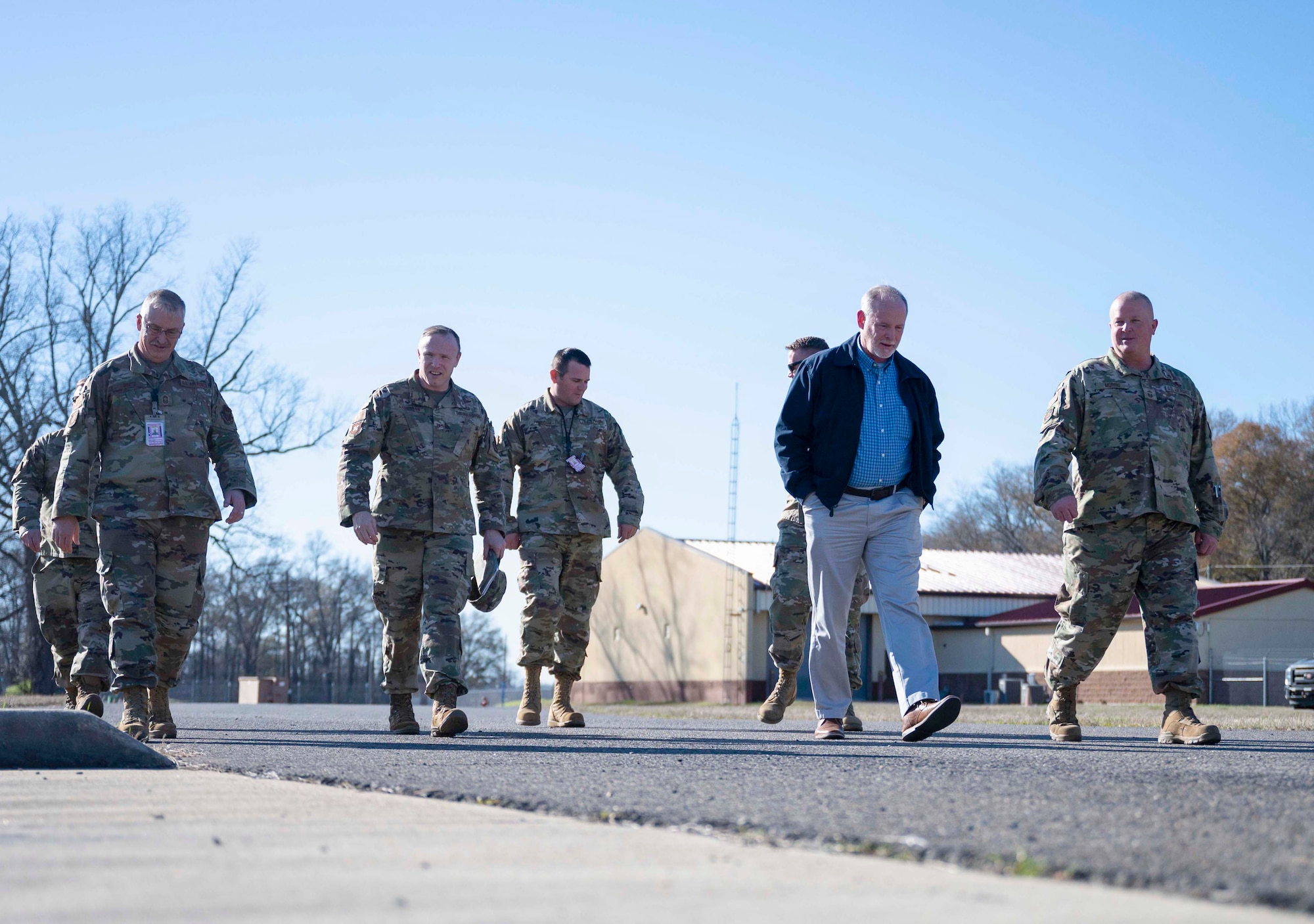 Seven men walk, while talking through the 307th Maintenance Squadron munitions area.