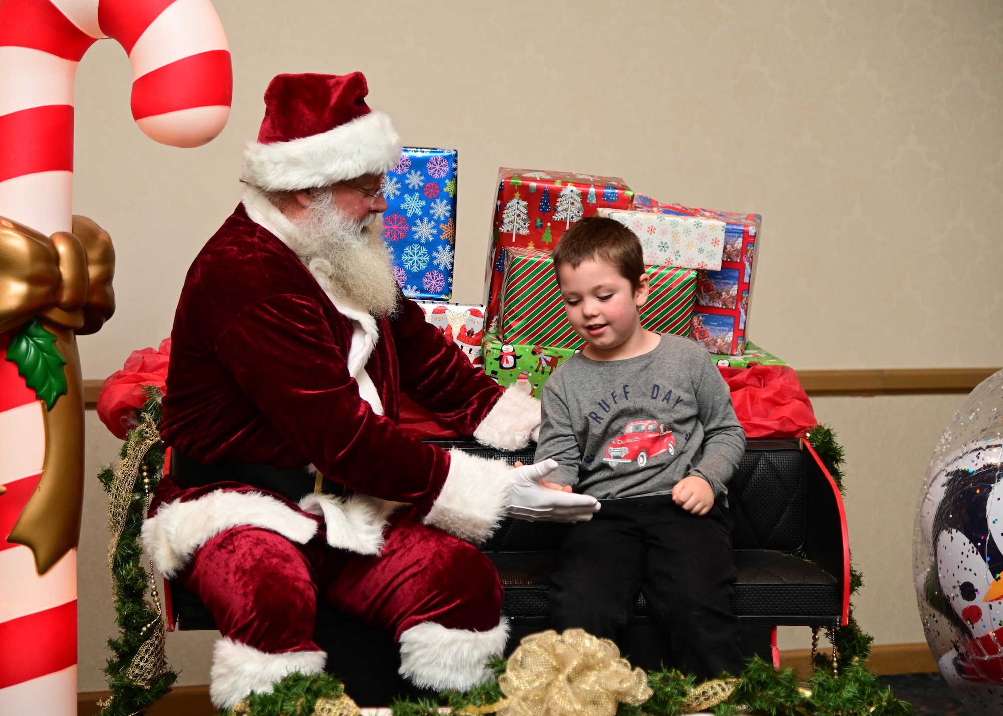 Santa gives a high-five to a child.