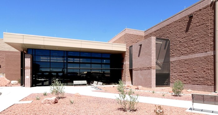 Ground view of the entrance to the building showing landscaping.