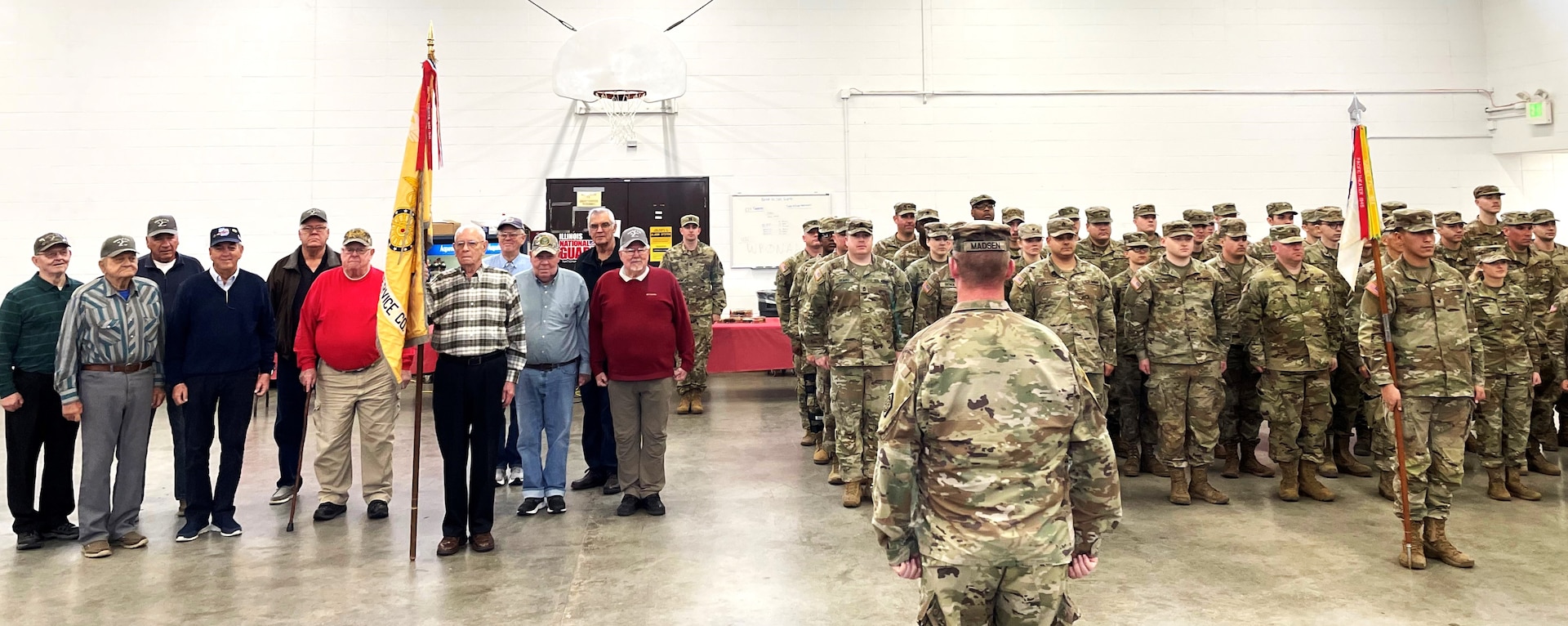 Vietnam Veterans of the Illinois Army National Guard's 126th Supply and Services Co. of Quincy, Illinois, stand in formation with Soldiers of the modern 126th Quartermaster Co. on Dec. 17 as part of the unit's family holiday party.