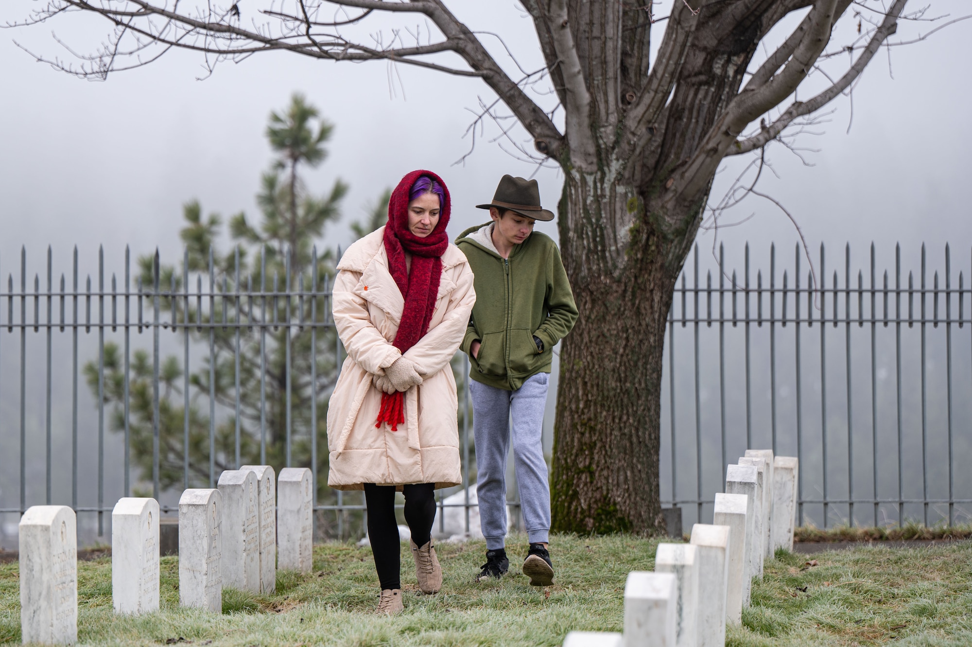 Two people walk in a cemetery