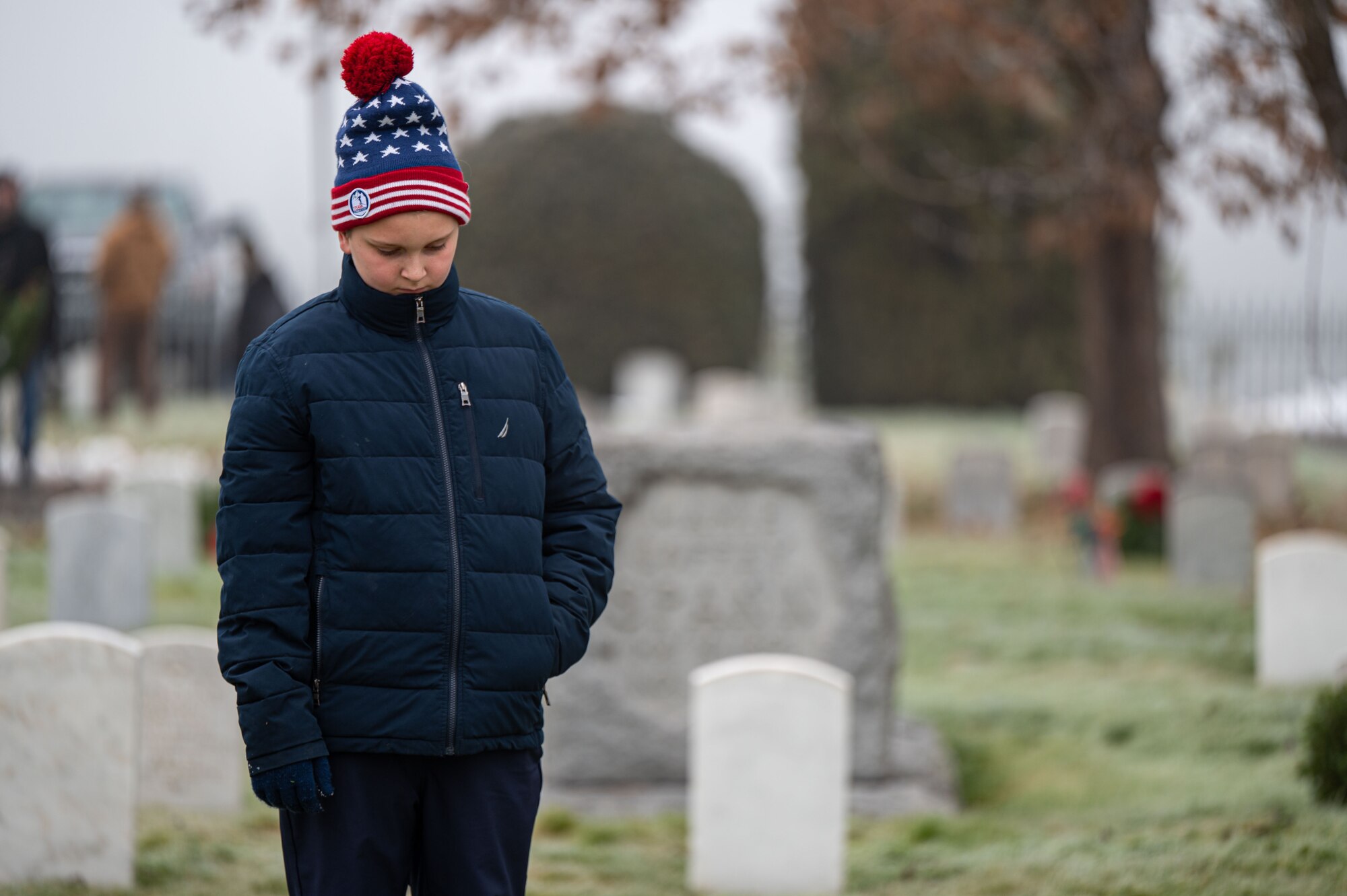 A child stands in a cemetery