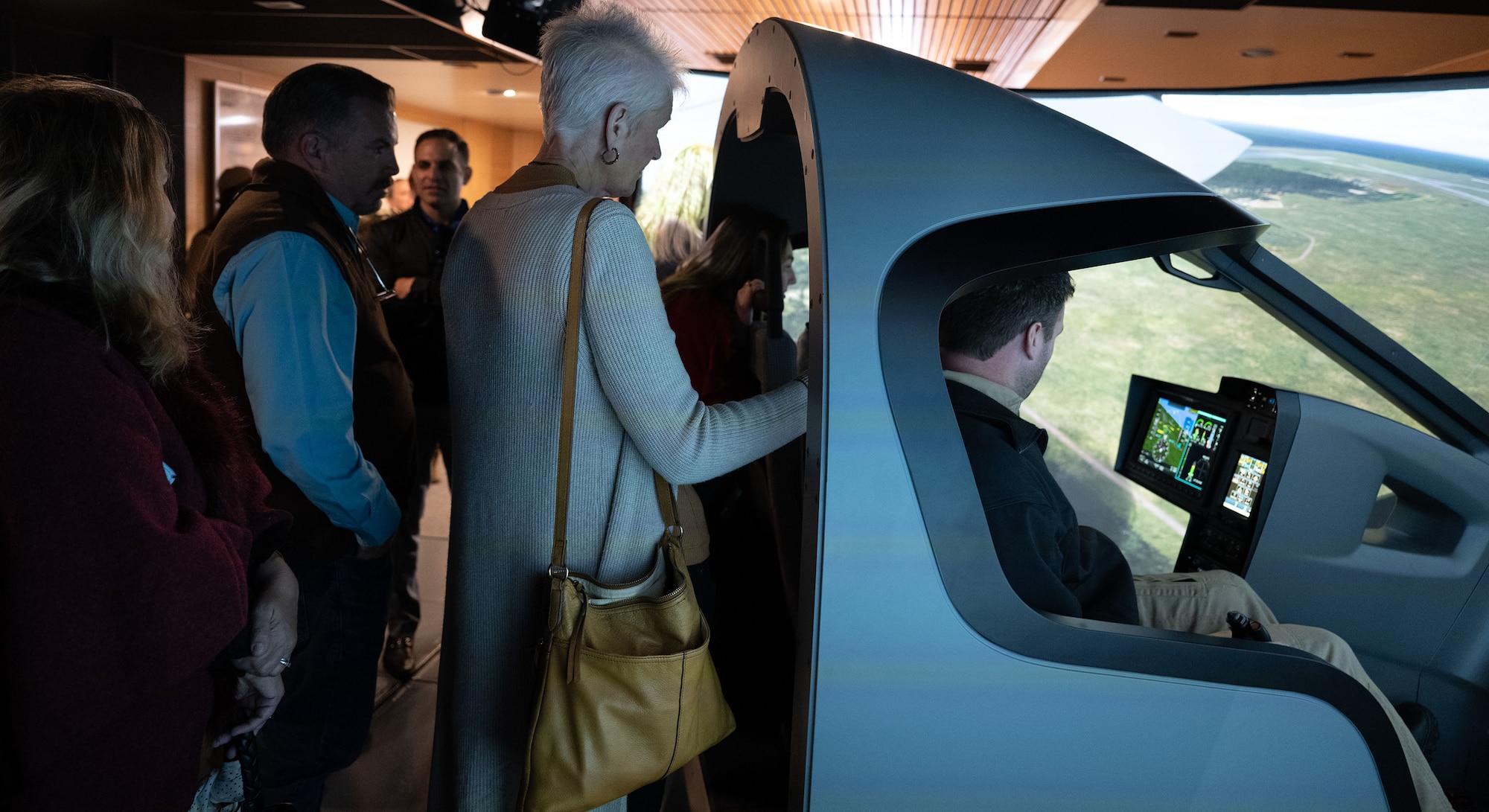 People gather around an aircraft simulator.