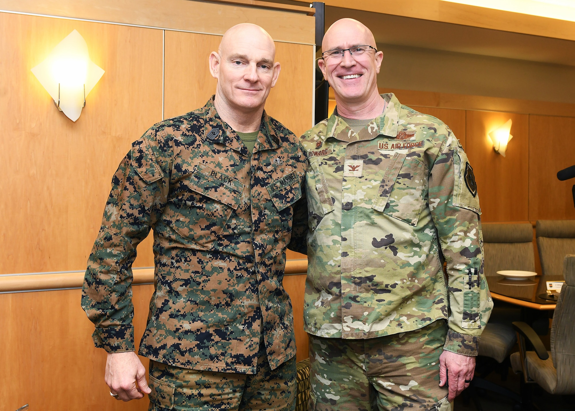 Two uniformed personnel stand posing for a photo.