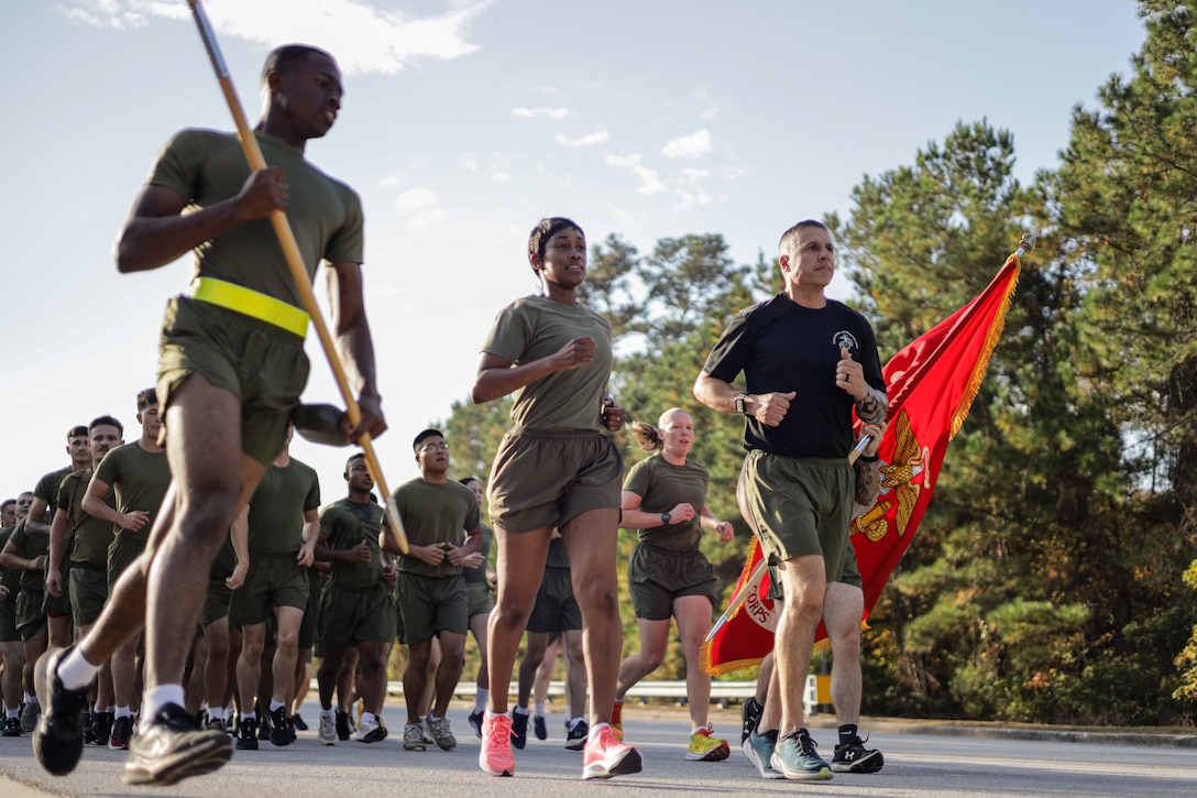 U.S. Marine Corps Col. Marshalee Clark, left, the commanding officer of Marine Corps Combat Service Support Schools, and Sgt. Maj. Nicholas Pascuzzi, right, the command senior enlisted leader of MCCSSS, lead a formation run on Camp Gilbert H. Johnson, North Carolina, Nov. 9, 2023. MCCSSS conducted a formation run to build camaraderie and to celebrate the 248th birthday of the United States Marine Corps. (U.S. Marine Corps photo by Chief Warrant Officer 2 Bryan Nygaard)