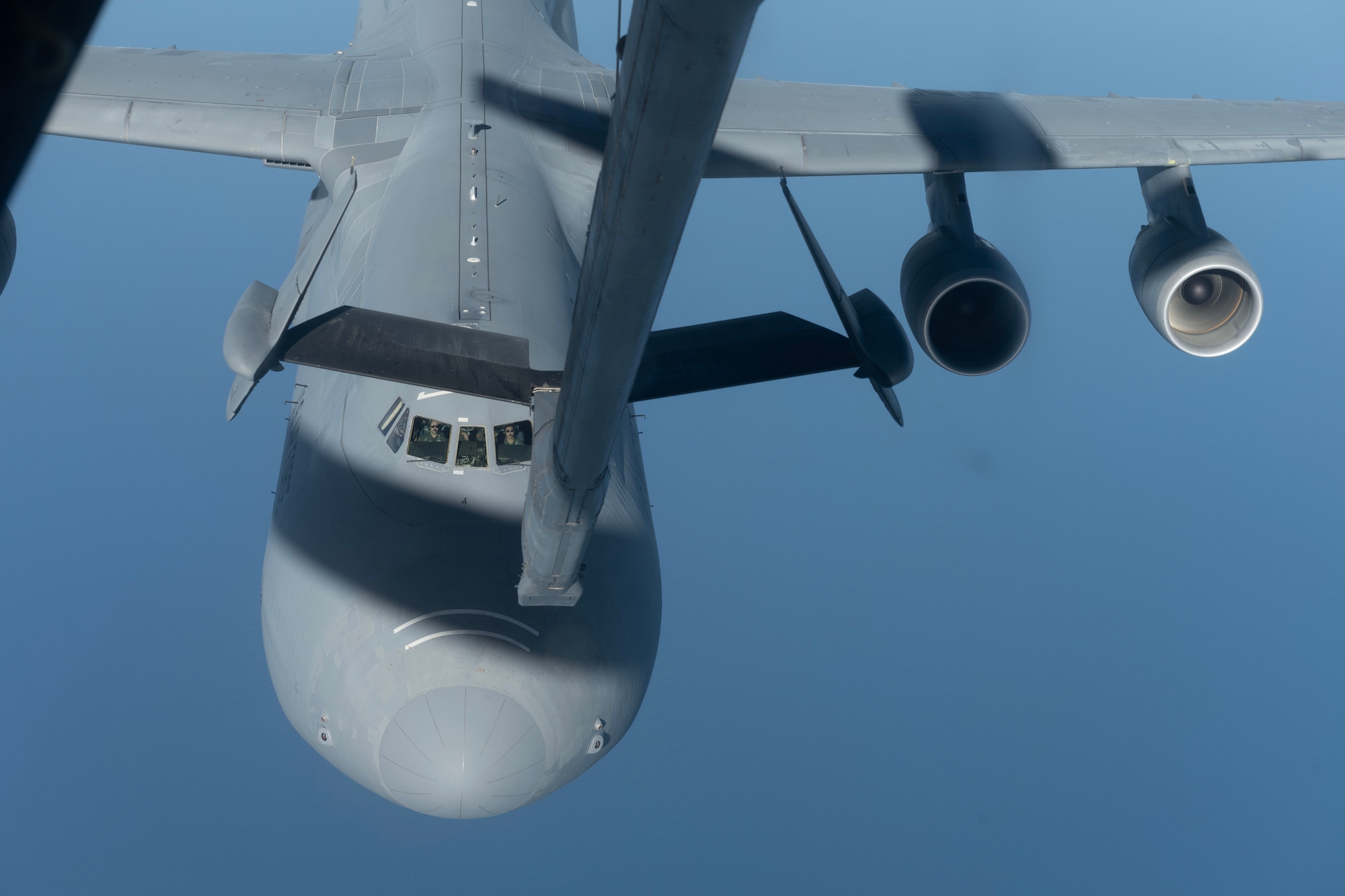A large military aircraft approaches another military aircraft