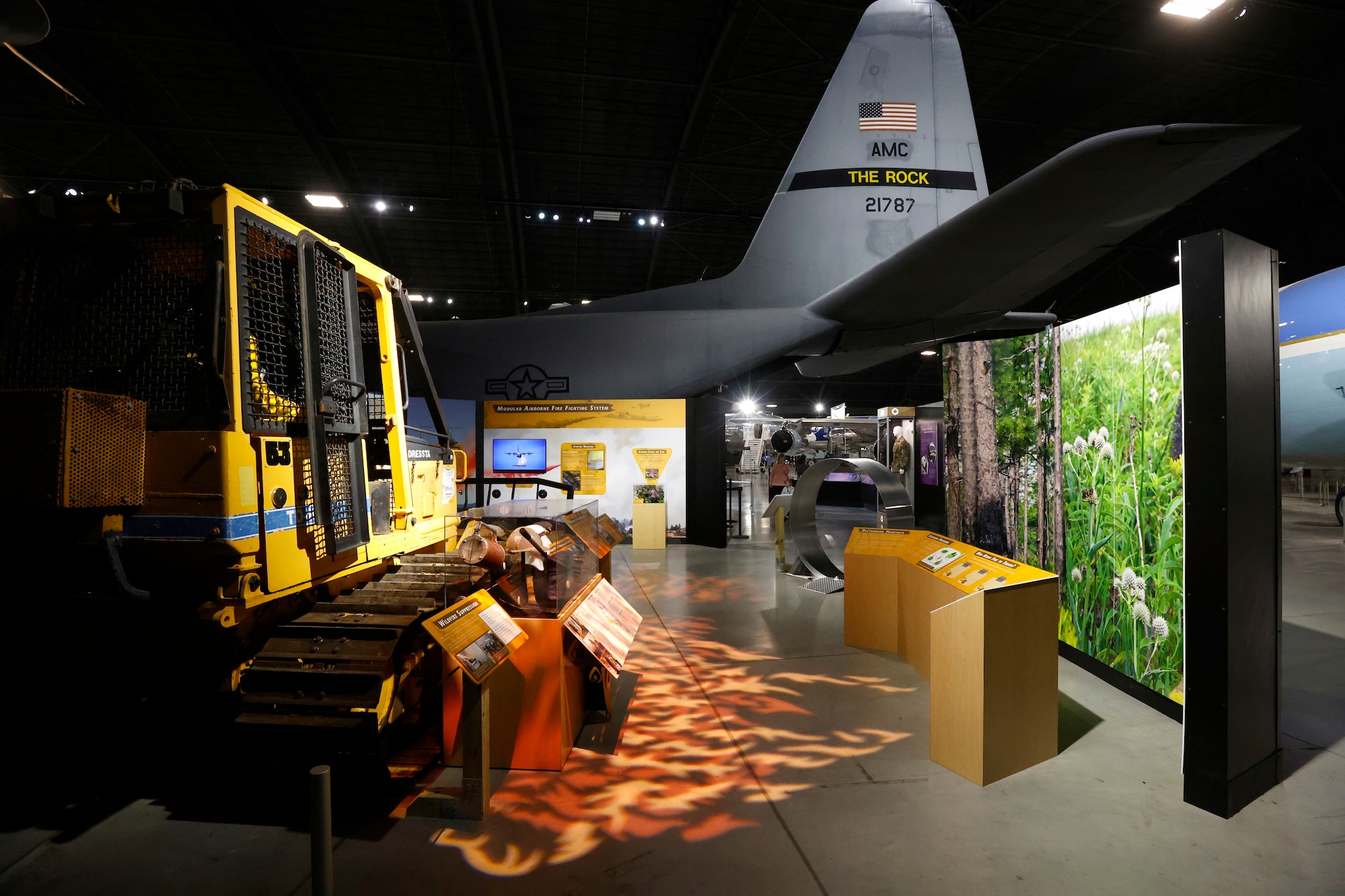 Image of the Global Firefighting mission of the USAF in the Humanitarian exhibit. Features a bulldozer on the left with a lighted image on the floor replicataing fire.
