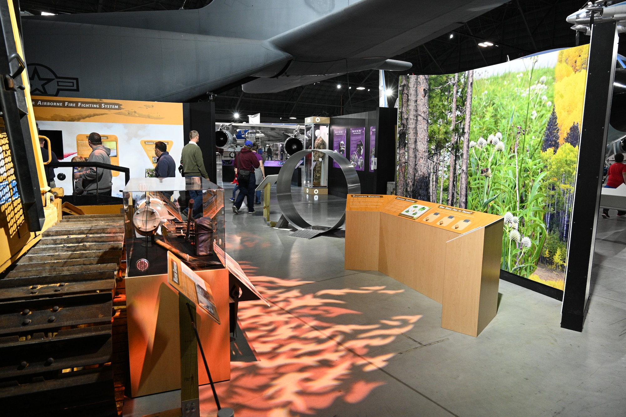 Image of the Global Firefighting mission portion of the Humanitarian Exhibit. On the left is the bulldozer used for firefighting with a light on the floor that replicates flames.