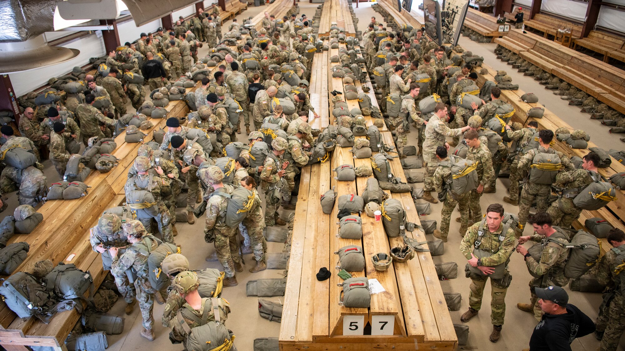people in military uniforms stand in rows inside a building
