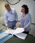 Bill Logsdon, Naval Surface Warfare Center Panama City Division Infrastructure Division (NSWC PCD) head, and Kelley Close, NSWC PCD Facilities head, review the design of the command Diving Equipment Fabrication Test and Assembly building’s canopy enclosure and extension, Oct. 25. This division consists of four branches—facilities, infrastructure support, environmental and safety—staffed by more than 40 personnel ranging from civilians to contractors to military service members from the Personnel Force Innovation (PFI) Program. (U.S. Navy photo by Anthony Powers)