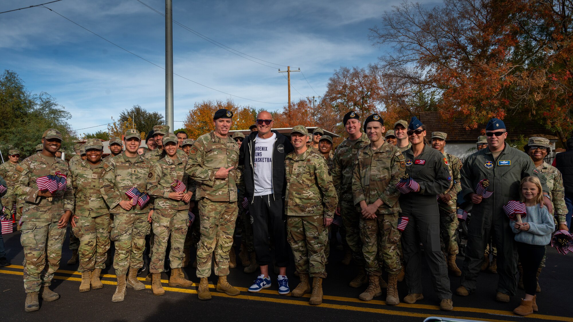Airmen Assigned to the 56th Fighter Wing pose for a photo with Rex Chapman, Phoenix Sun’s alumni player, leading up to the Fiesta Bowl Parade, Dec. 16, 2023, in Phoenix, Arizona.