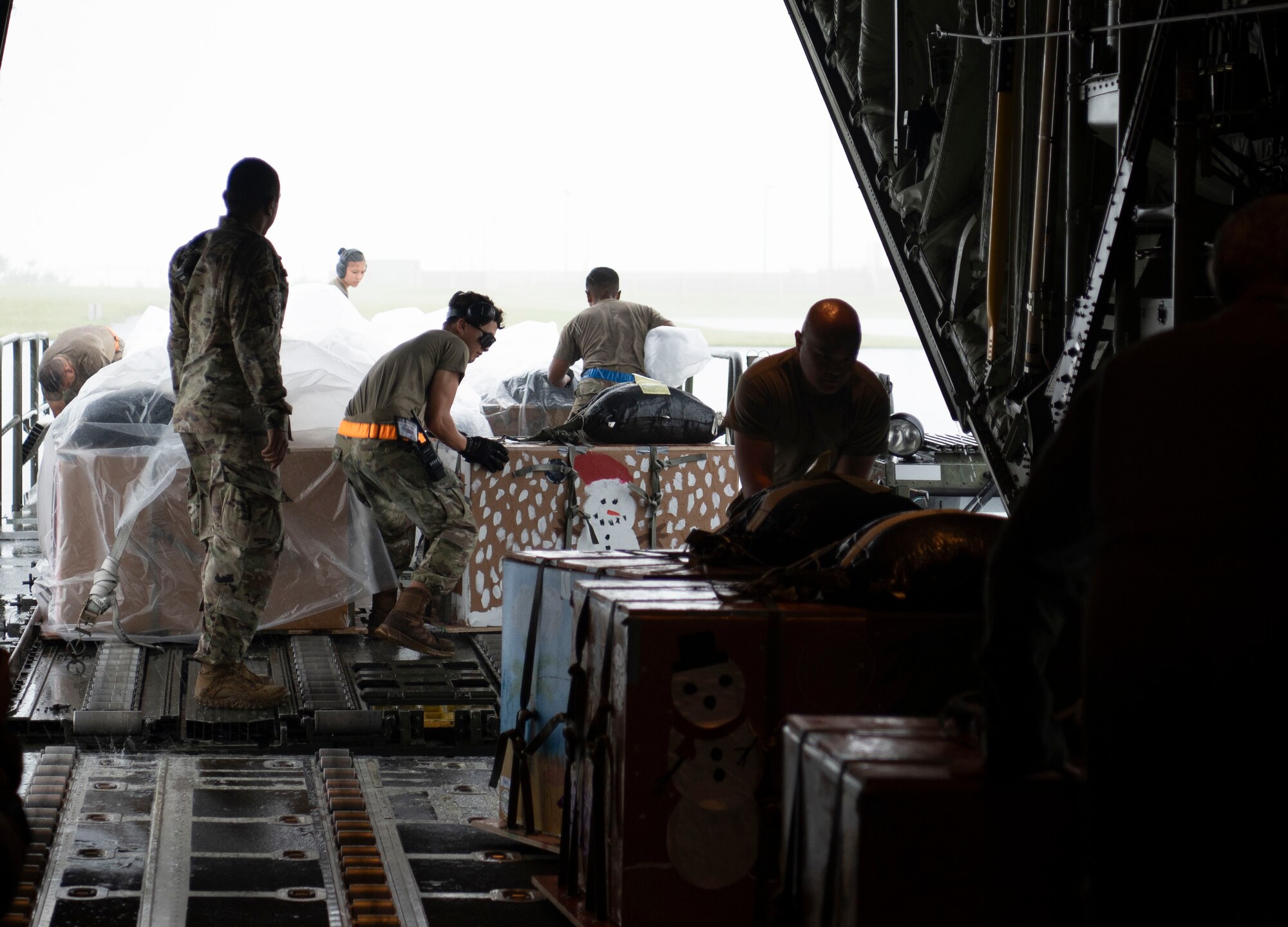 U.S. Air Force Airmen load supply bundles on a C-130J Super Hercules during Operation Christmas Drop at Andersen Air Force Base, Guam, Dec. 3, 2023.