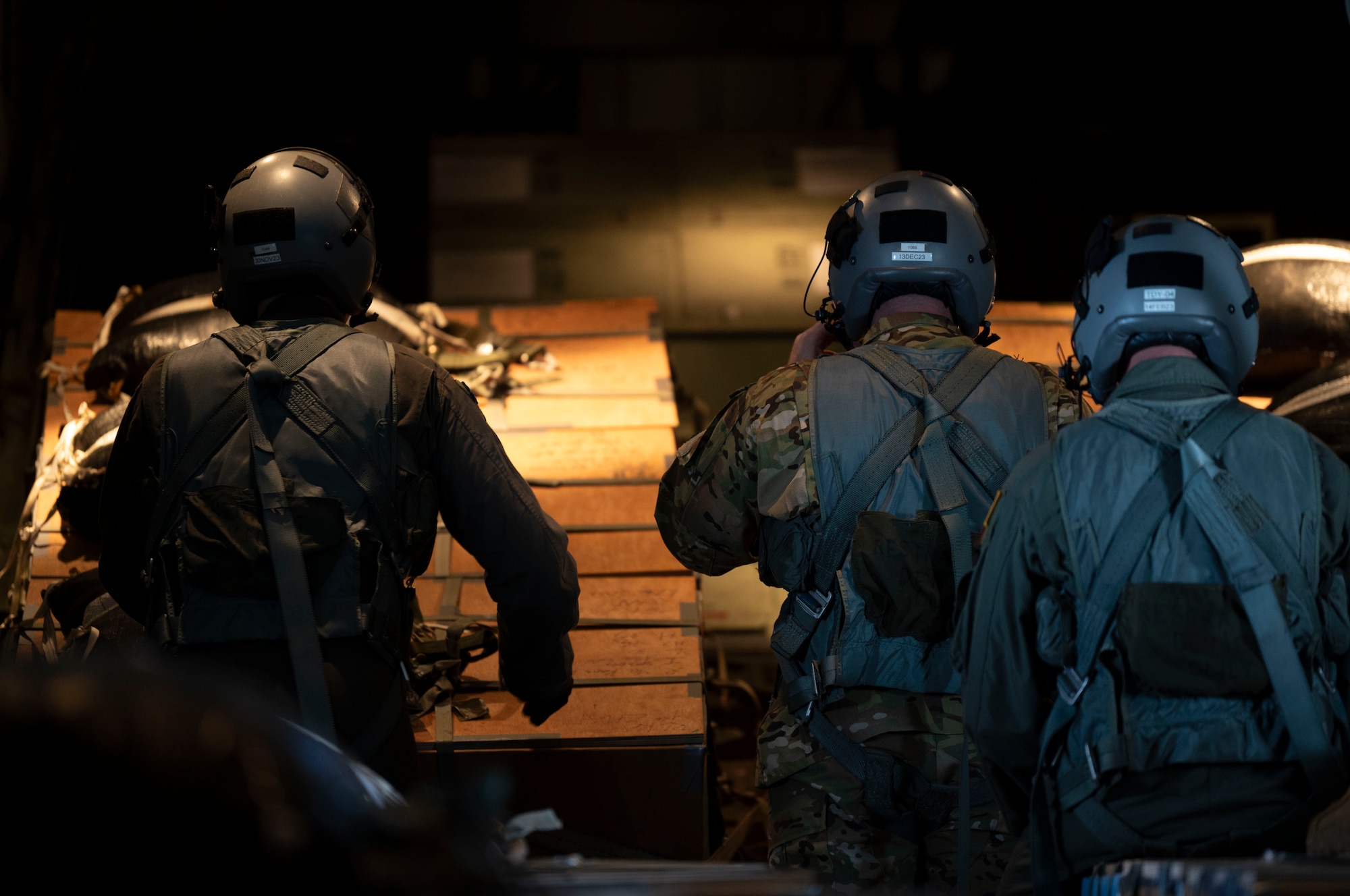 U.S. Air Force Airmen prepare to drop supply bundles out of a C-130J Super Hercules.