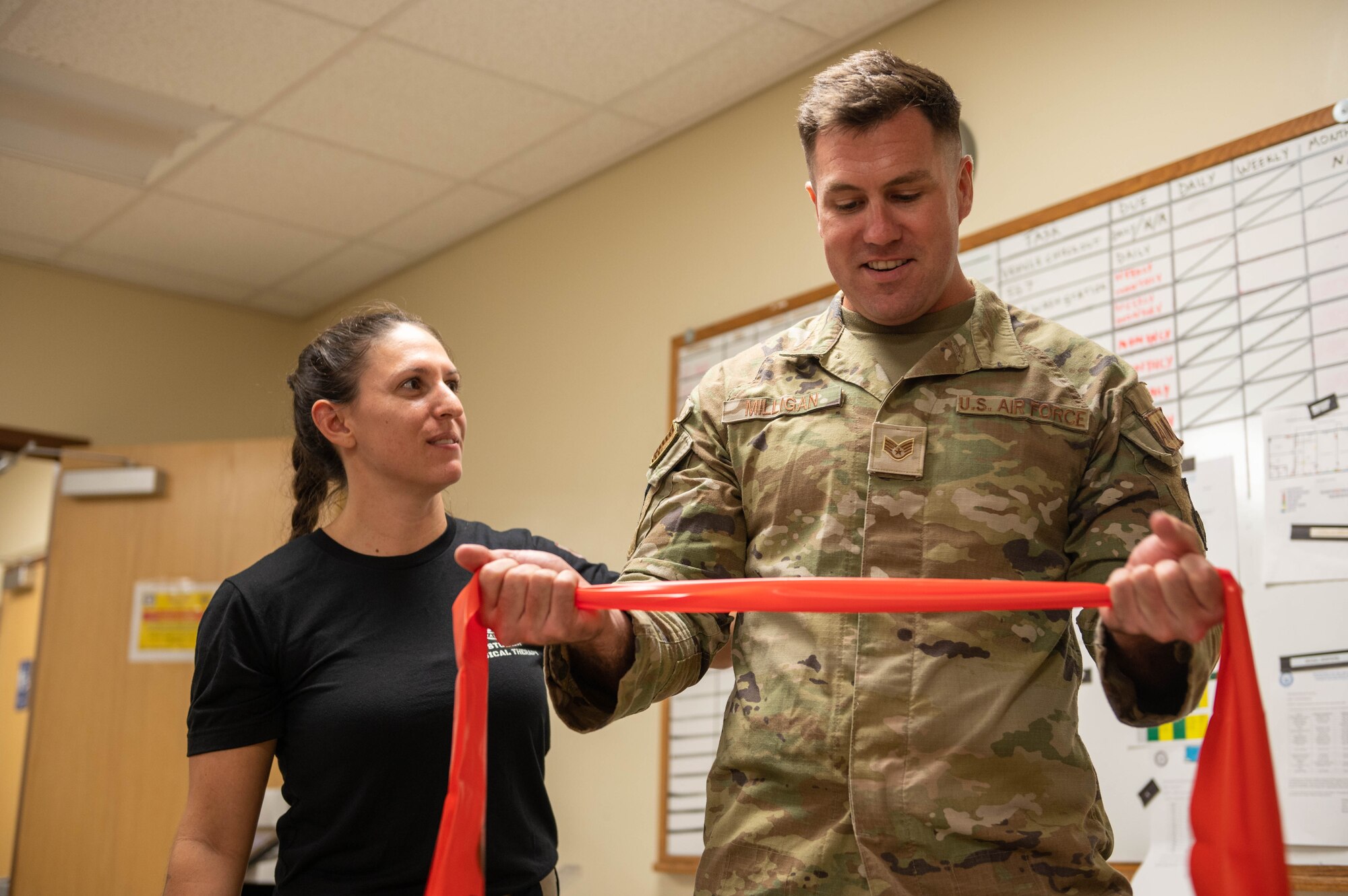U.S. Air Force Maj. Meredith Studer, 36th Medical Group physical element chief, utilizes bands during a physical therapy session with U.S. Air Force Staff Sgt. Lee Milligan, 36th Munitions Squadron resource advisor, at Andersen Air Force Base, Guam, Nov. 3, 2023. The Operational Support Team is a medical team of active duty and civilian personnel that consist of a physical therapist, a psychologist, a social worker, a strength and conditioning specialist and a team specialist that get attached to units for a period of time to improve mental and physical health. (U.S. Air Force photo by Airman 1st Class Allon Lapaix)