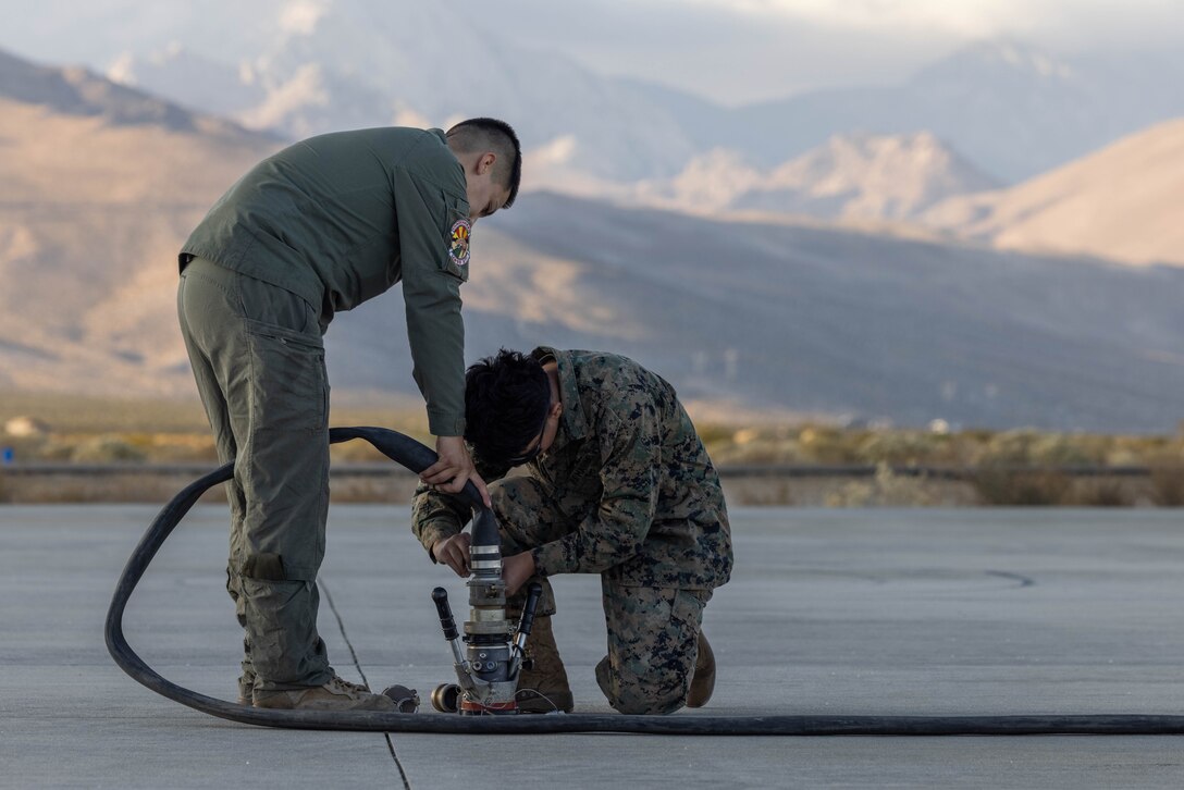 U.S. Marine Corps Lance Cpl. Daniel LopezAlonso and Pfc. Allen Michel, bulk fuel specialists with Marine Wing Support Squadron (MWSS) 371, Marine Air Control Group 38, 3rd Marine Aircraft Wing, establish a connection between a hose and fuel bladders at a forward arming and refueling point in support of Exercise Steel Knight 23.2 at Inyokern Airfield, California, Nov. 30, 2023. A FARP is designed to provide refueling and rearming to rotary or fixed-wing assets enhancing reach and capacity of air operations in forward environments. Steel Knight 23.2 is a three-phase exercise designed to train I Marine Expeditionary Force in the planning, deployment and command and control of a joint force against a peer or near-peer adversary combat force and enhance existing live-fire and maneuver capabilities of the Marine Air-Ground Task Force. (U.S. Marine Corps photo by Lance Cpl. Jennifer Sanchez)