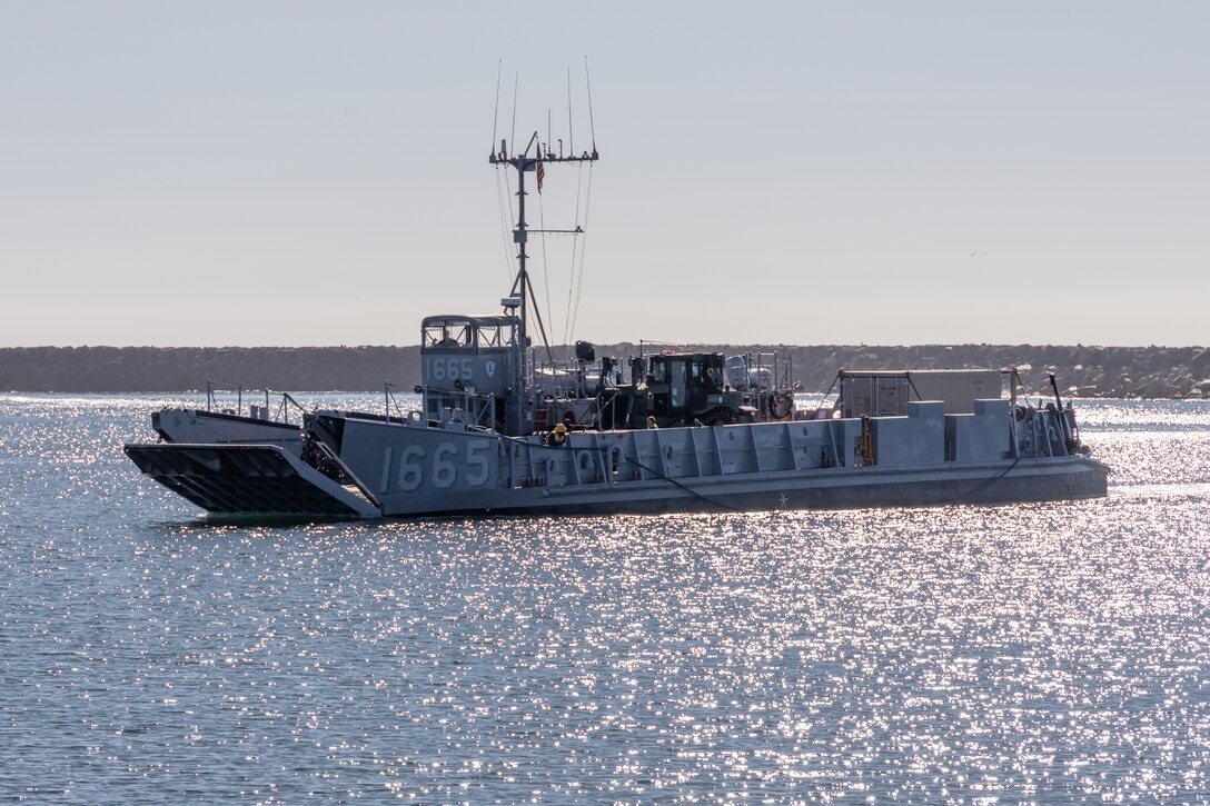 U.S. Navy Landing Craft, Utility 1665, assigned to Assault Craft Unit 1, approaches the shore to offload cargo during Exercise Steel Knight 23.2 at Marine Corps Base Camp Pendleton, California, Dec. 2, 2023. The Marine Corps Warfighting Lab Experimentation Division tests expeditionary 3D printing during SK 23.2 to shape Force Design for future Marine Corps and joint exercises. Steel Knight is a three-phase exercise designed to train I Marine Expeditionary Force in the planning, deployment and command and control of a joint force to enhance capabilities of the Marine Air-Ground Task Force. (U.S. Marine Corps photo by Sgt. Anabel Abreu Rodriguez)
