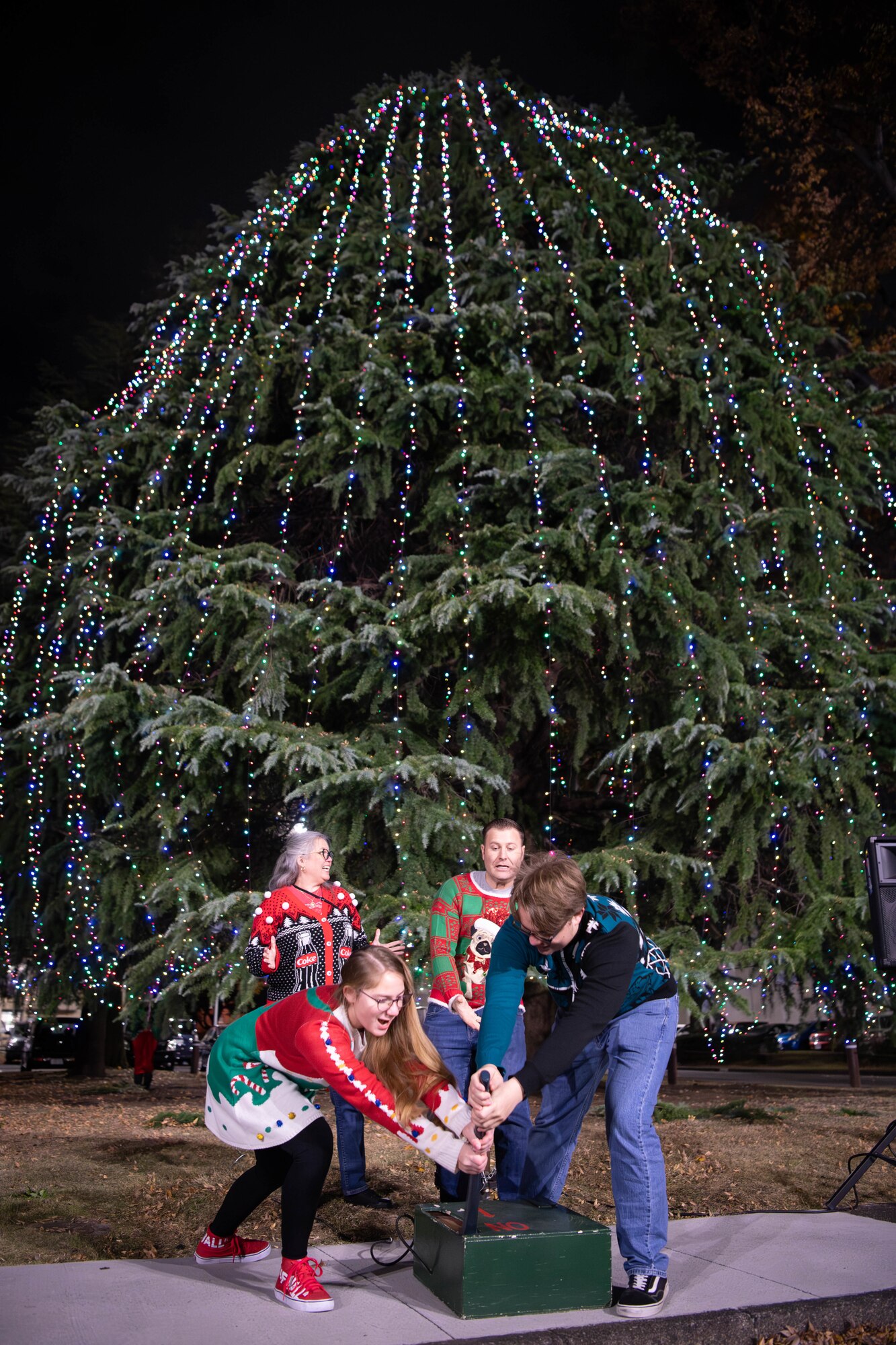 A family pulls a lever to light a Christmas tree in front of the main chapel at Yokota Air Base, Japan.