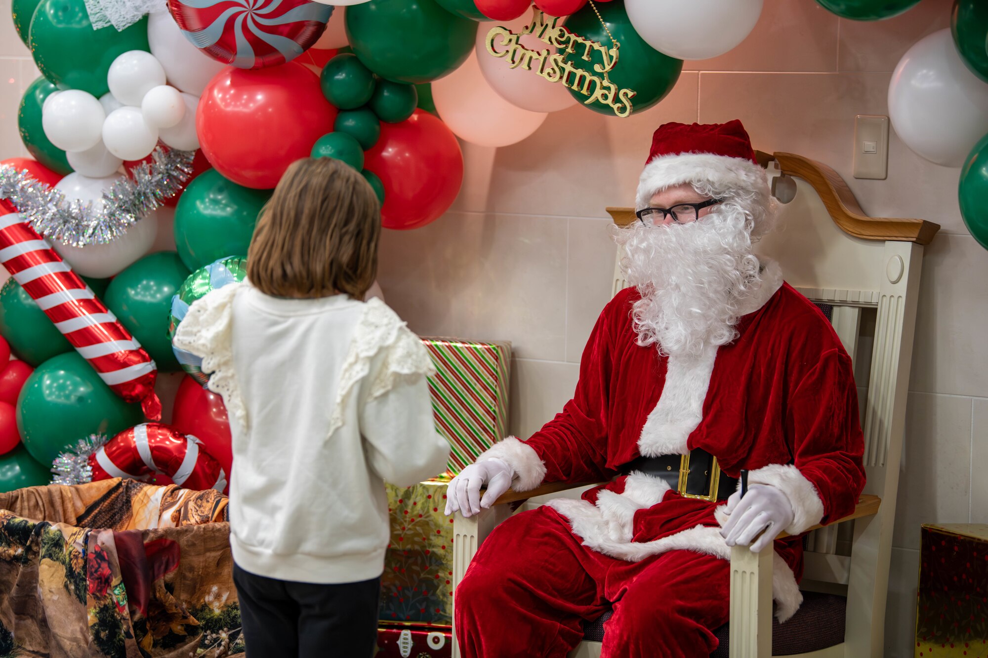 A child tells Santa Claus what she wants for Christmas during a meet-and-greet at the main chapel on Yokota Air Base, Japan.