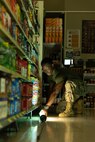 U.S. Marine Corps Cpl. George Okyne, an electrician with Headquarters Battalion, 3rd Marine Division, arranges temporary lights at the Camp Courtney Commissary, Okinawa, Japan, August 4, 2023. Service members with Headquarters Battalion and 4th Marine Regiment, 3rd Marine Division, installed temporary lighting to reopen the commissary following a power outage caused by Typhoon Khanun. (U.S. Marine Corps photo by Cpl. Stephen Holland)