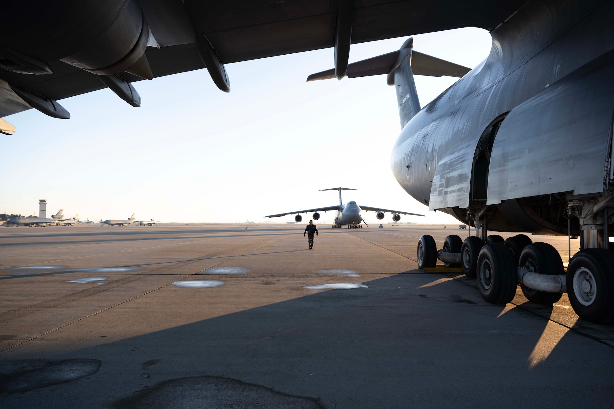 An Airman walks around a large military aircraft