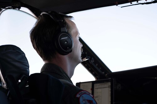 An Airman sits in the pilot seat of a military aircraft