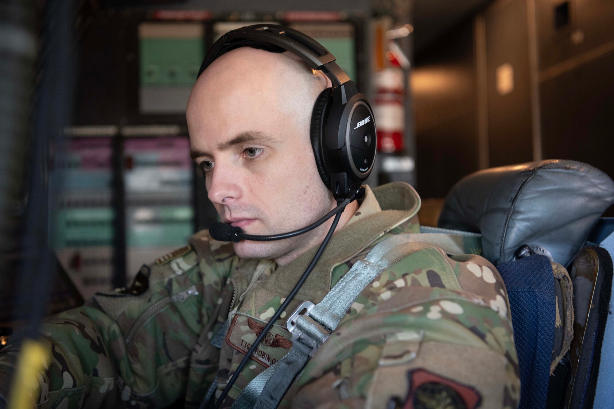 An Airman sits in the flight deck of a military aircraft