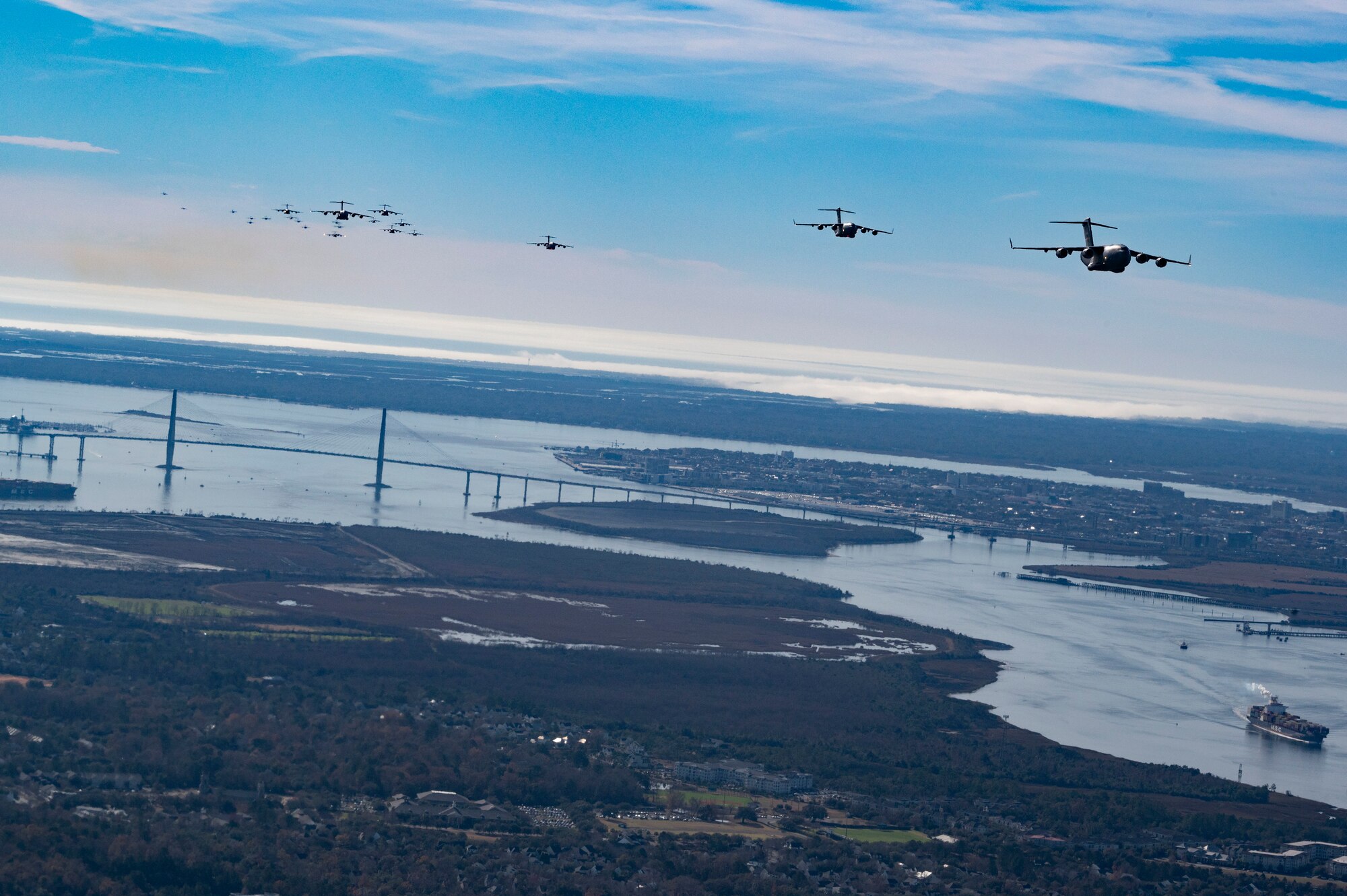 C-17 Globemaster III’s assigned to the 437th Airlift Wing fly over Charleston, South Carolina for a mass generation exercise, Jan. 5, 2023. This mission generation exercise kicks off Mobility Guardian 23 and involved the launch of 24 C-17s for the largest-ever show-of-force formation flight over Charleston Harbor. After the flyover, the formation dispersed to sharpen agile combat employment concepts that leverage rapid mobility to maximize lethality. (U.S. Air Force photo by Tech. Sgt. Michael Cossaboom)