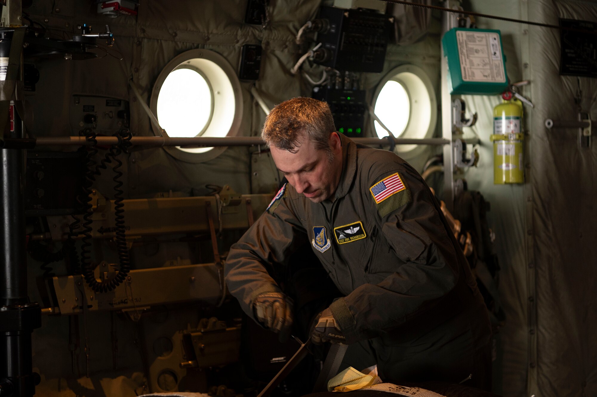 U.S. Air Force Staff Sgt. Eric Richardson, 36th Airlift Squadron safety non-commissioned officer in charge and loadmaster, Yokota Air Base, Japan, secures supply bundles on to a C-130J Super Hercules before takeoff during Operation Christmas Drop at Andersen Air Force Base, Guam, Dec. 3, 2023.