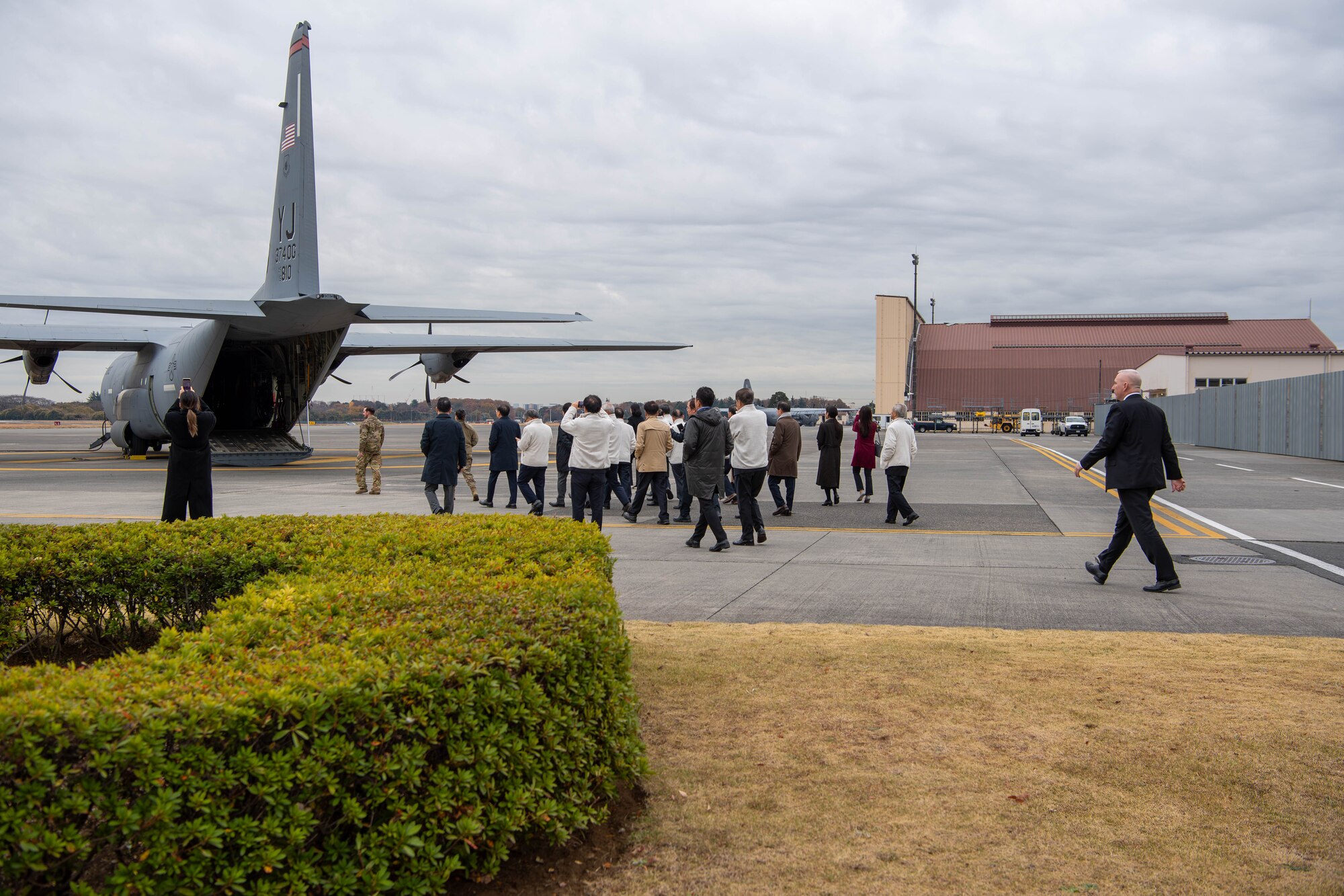 Members of the Korea Peace Foundation make their way to a C-130J Super Hercules at Yokota Air Base, Japan.