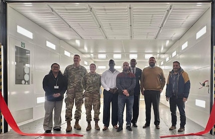 The U.S. Army Garrison Benelux command team, Col. Lindsay Matthews and Command Sgt. Maj. Gary Yurgans, pose for a group photo with the former Logistics Readiness Center Benelux director, DJ Jackson; the interim director, Diana Ioane; the LRC Benelux maintenance chief, Patrick Brown; and the LRC Benelux paint and body shop team to celebrate the opening of the new paint booth at Chièvres Air Base, Belgium, Dec. 18. (U.S. Army courtesy photo)